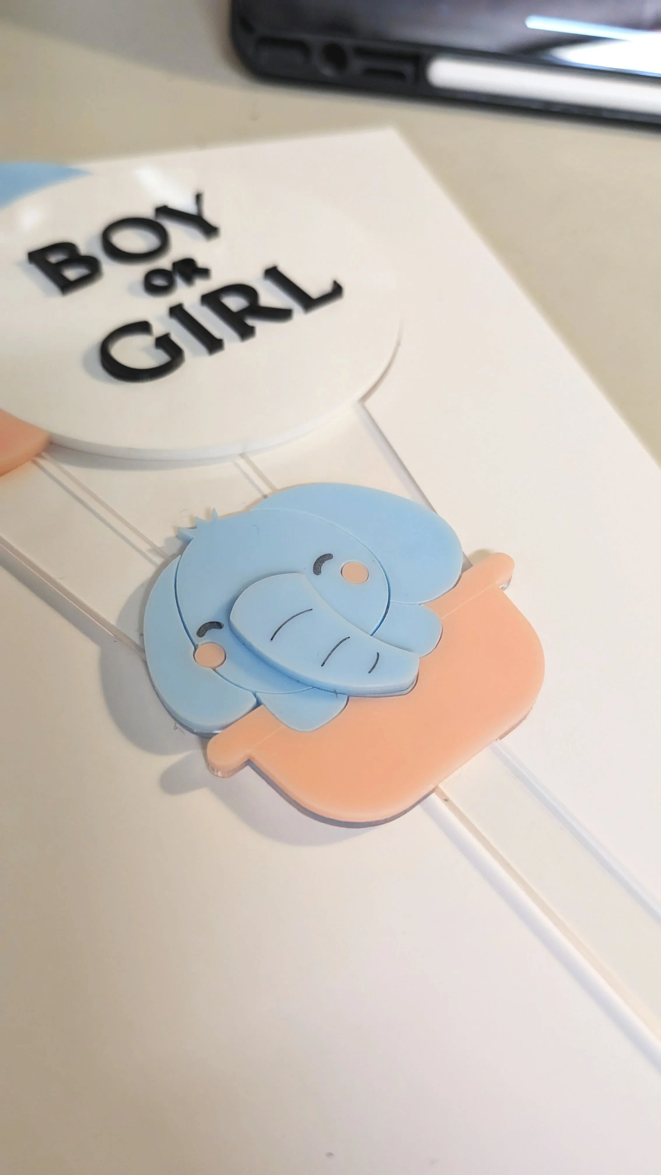 Close up of the baby elephant custom cake topper which shows layers of acrylic.