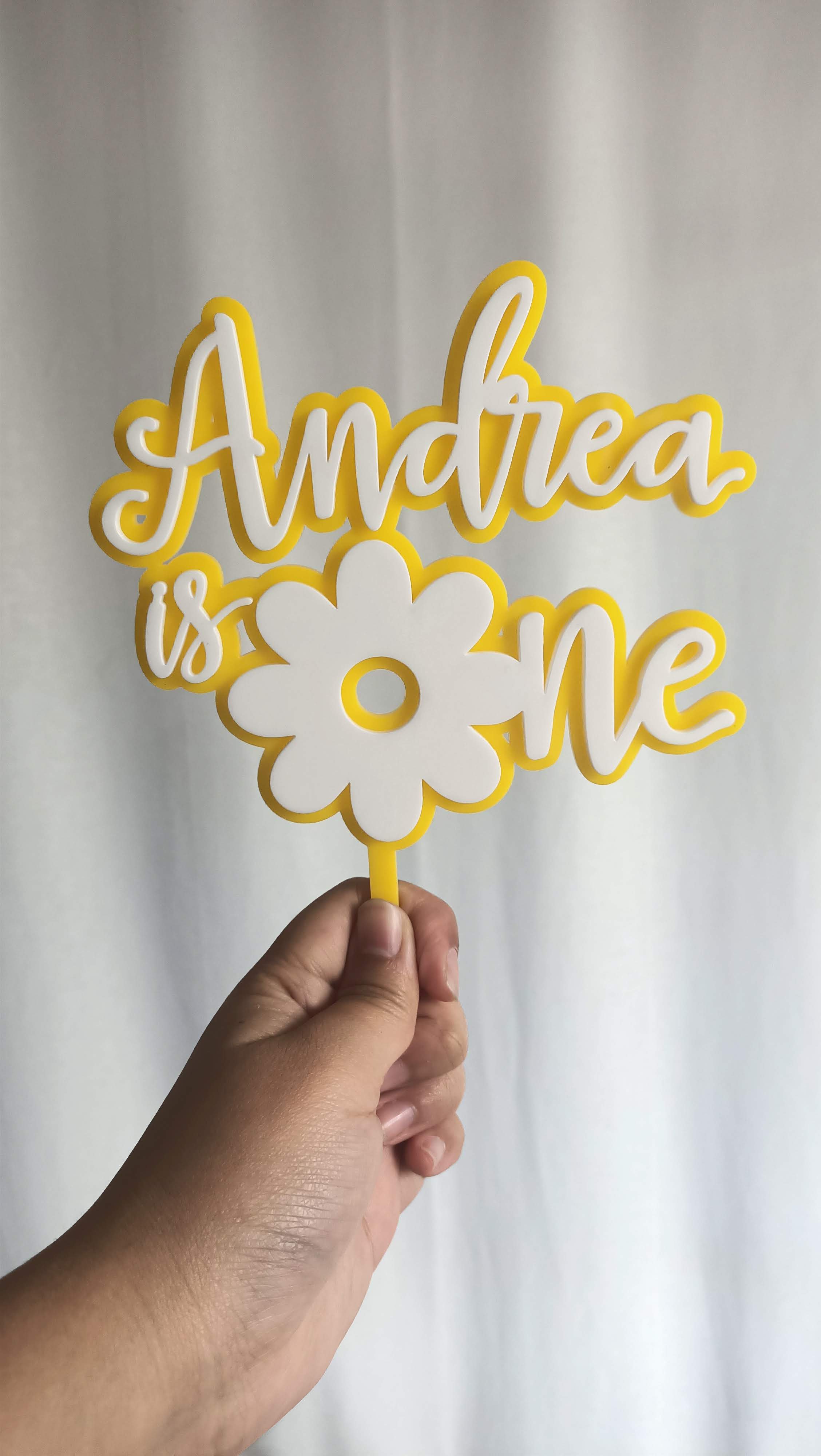 A custom cake topper for a flower themed cake.