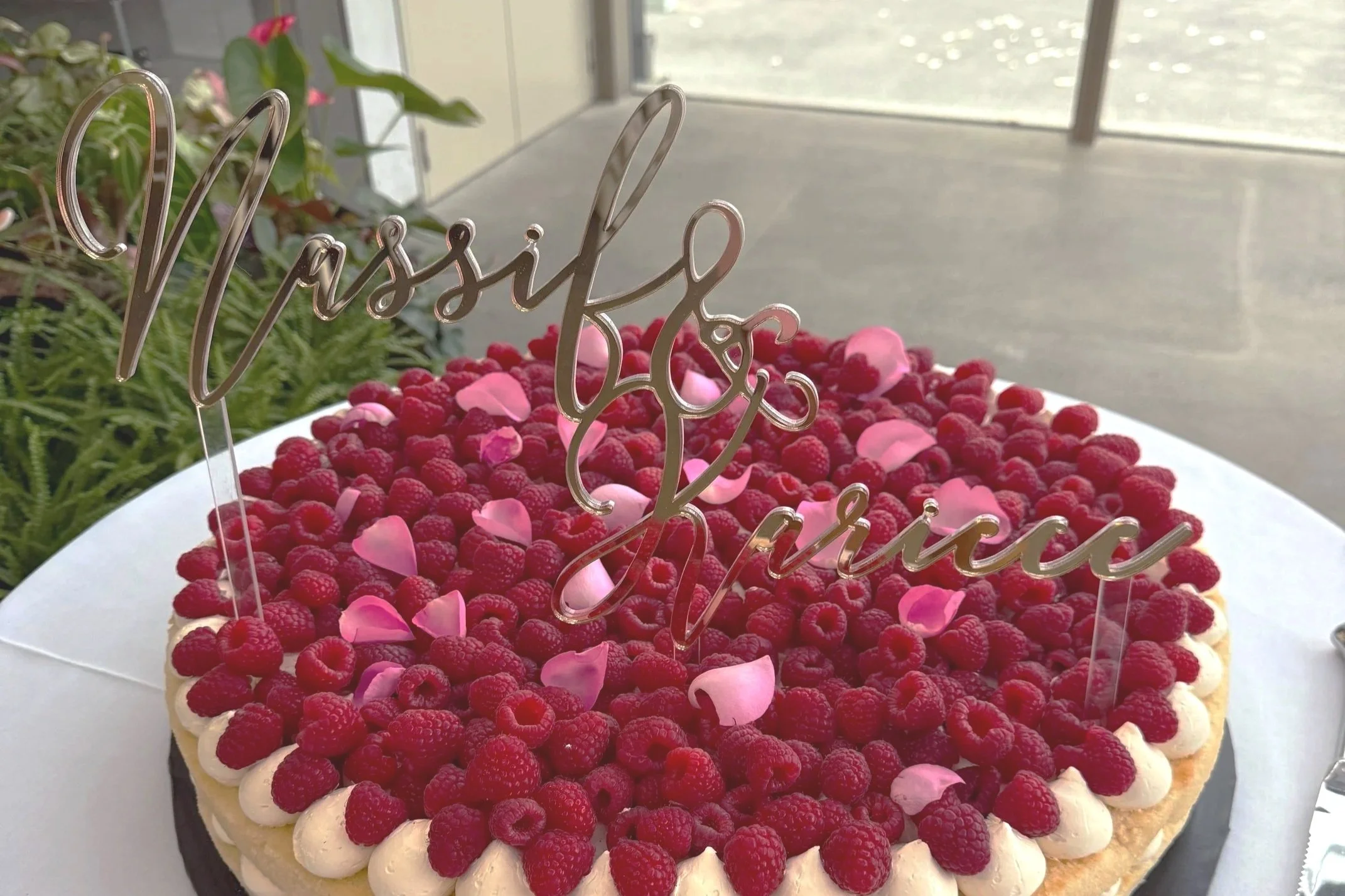 A Stacy Brewer raspberry cake with a floating gold mirror topper that says Nassif & Kariece. Made for a wedding event