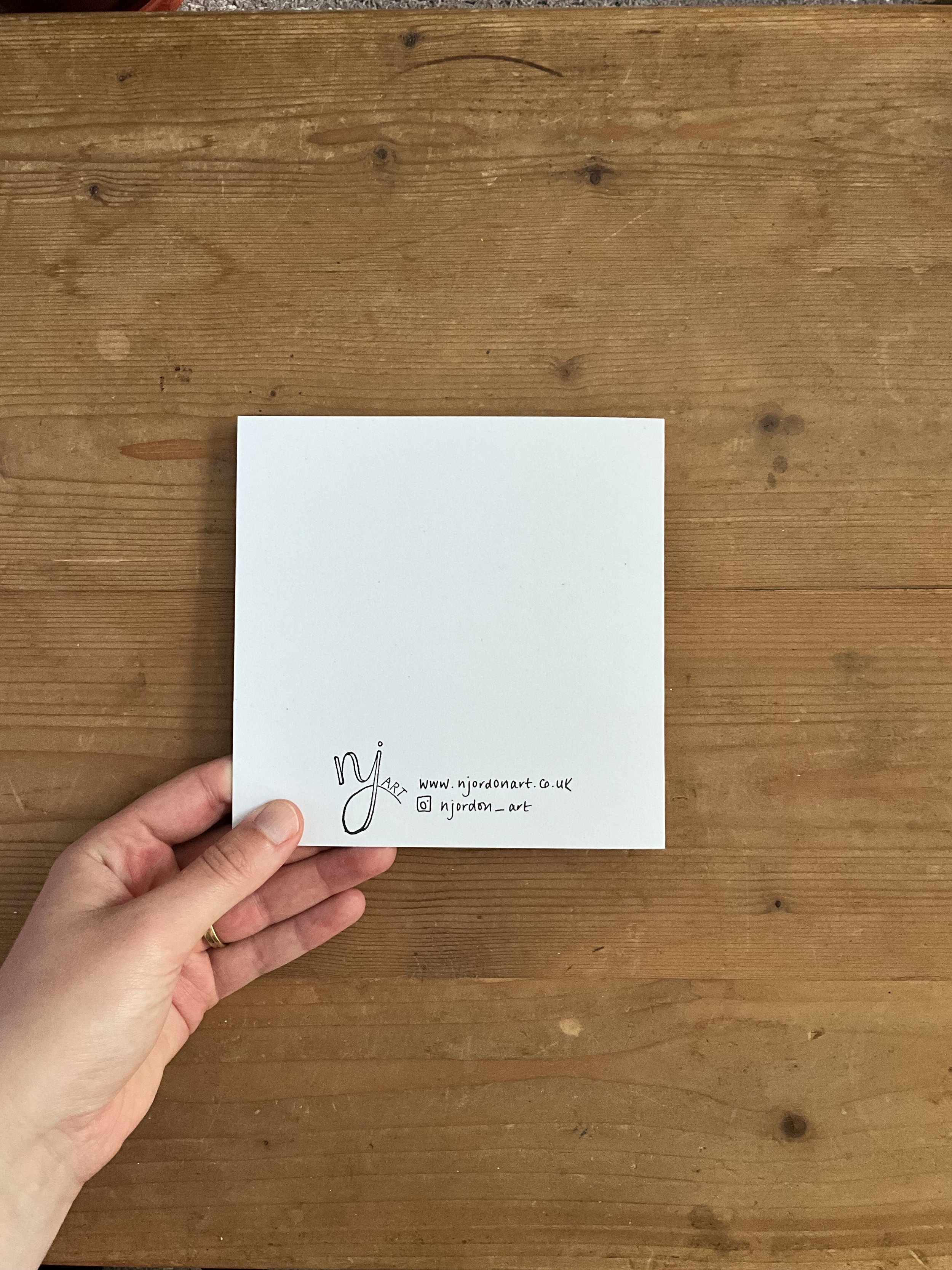 Back of diamond floral greeting card (square), held in hand