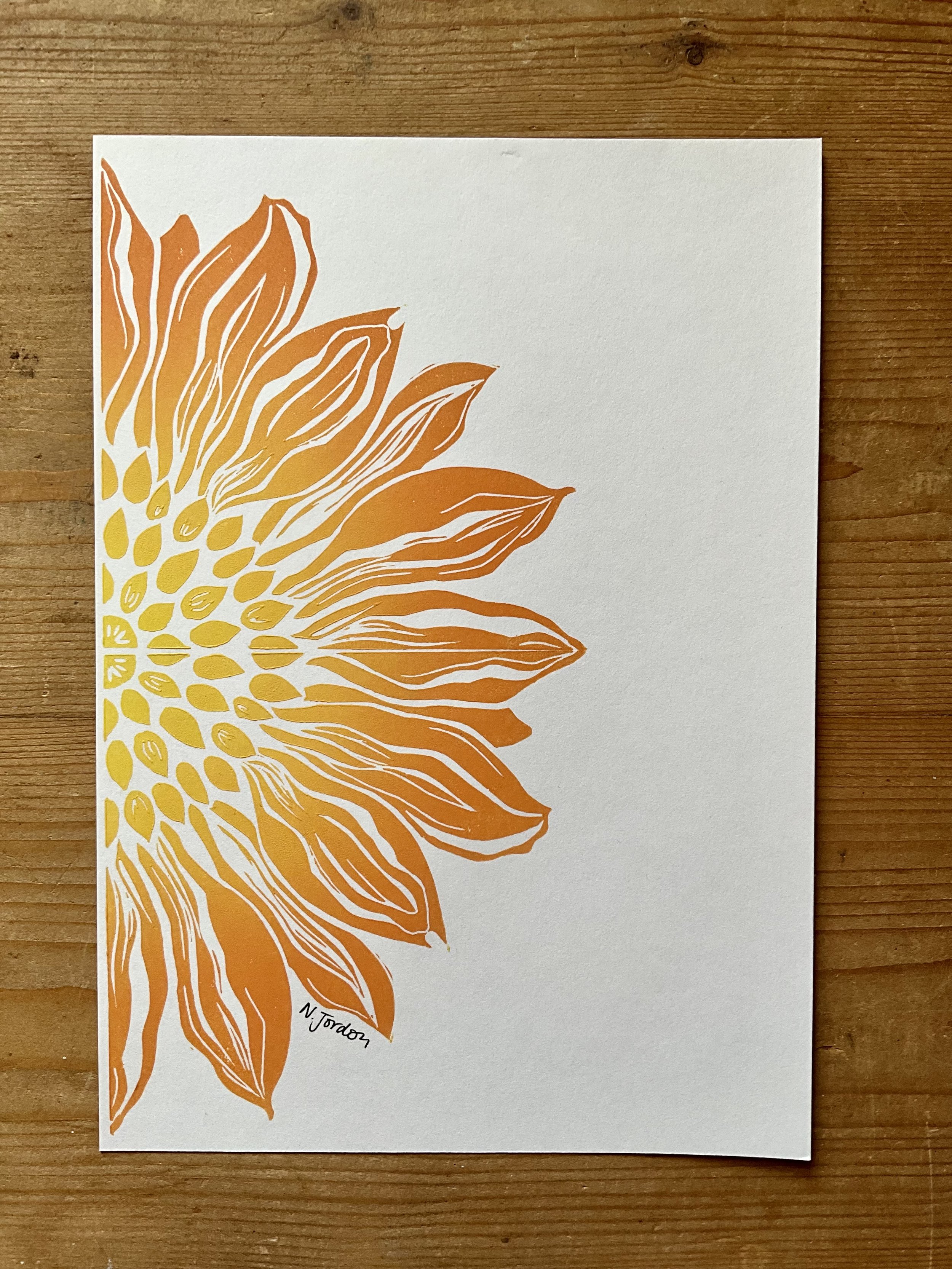 Close up of sunflower original lino cut print, in A5. Hand printed in orange-yellow ombré.