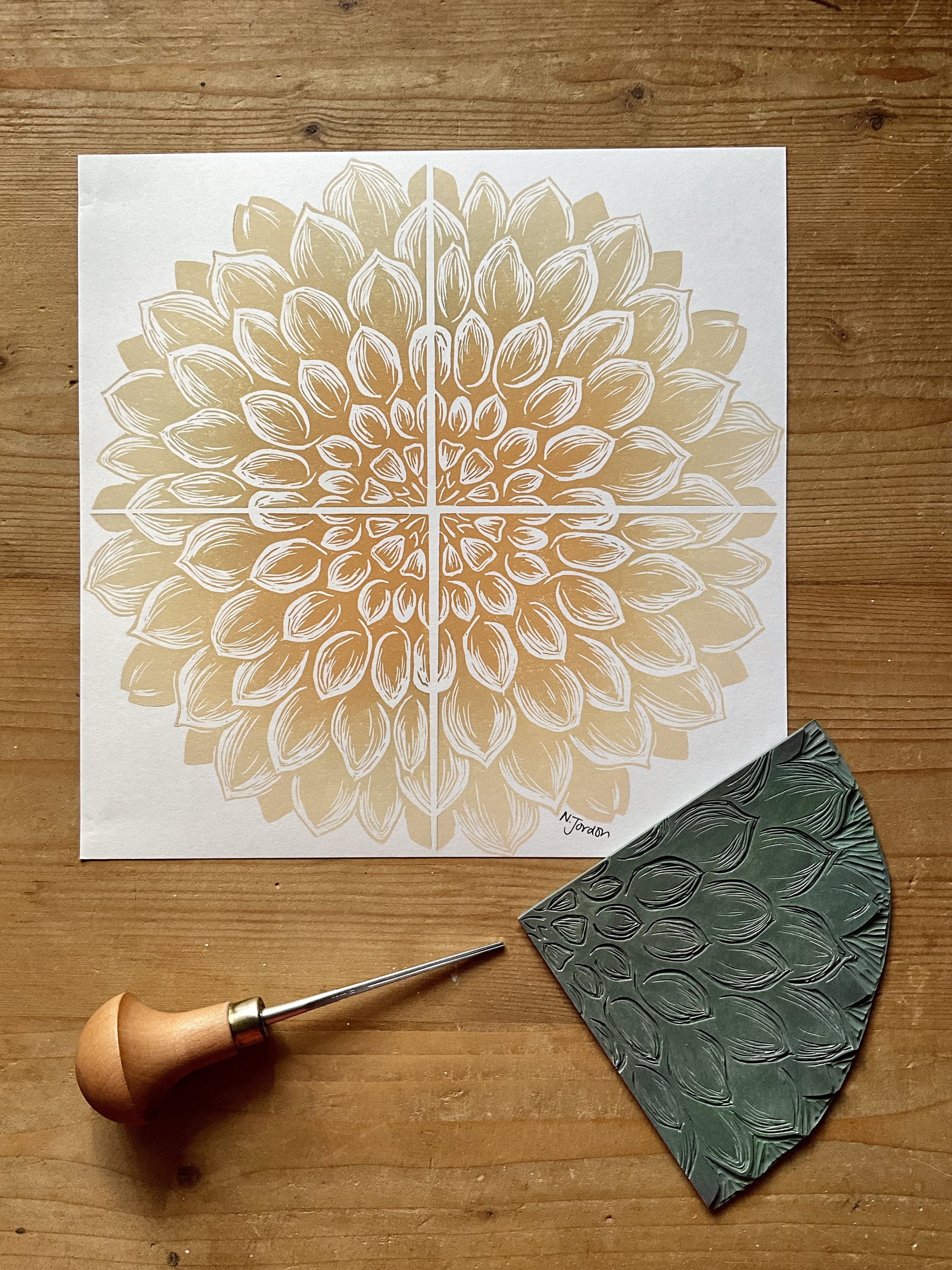 Full dahlia original lino cut print, in 21x21cm square. Hand printed in sand/tan ombré. Photo also shows lino carving tool and the dahlia block used to print this piece.