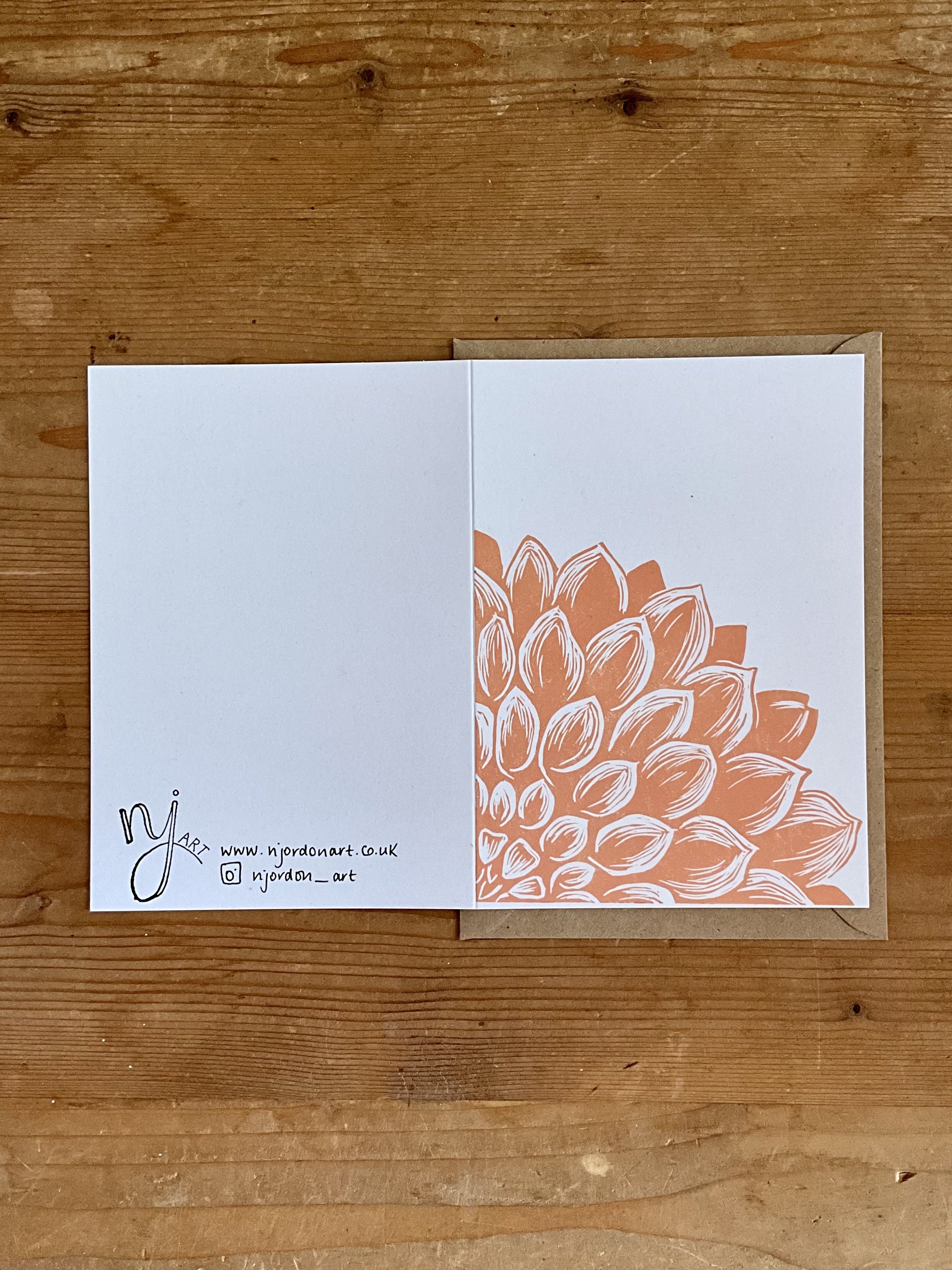 Photo of A6 dahlia quarter greeting card, laid flat to show front and back of the card. Behind card is a Kraft brown envelope