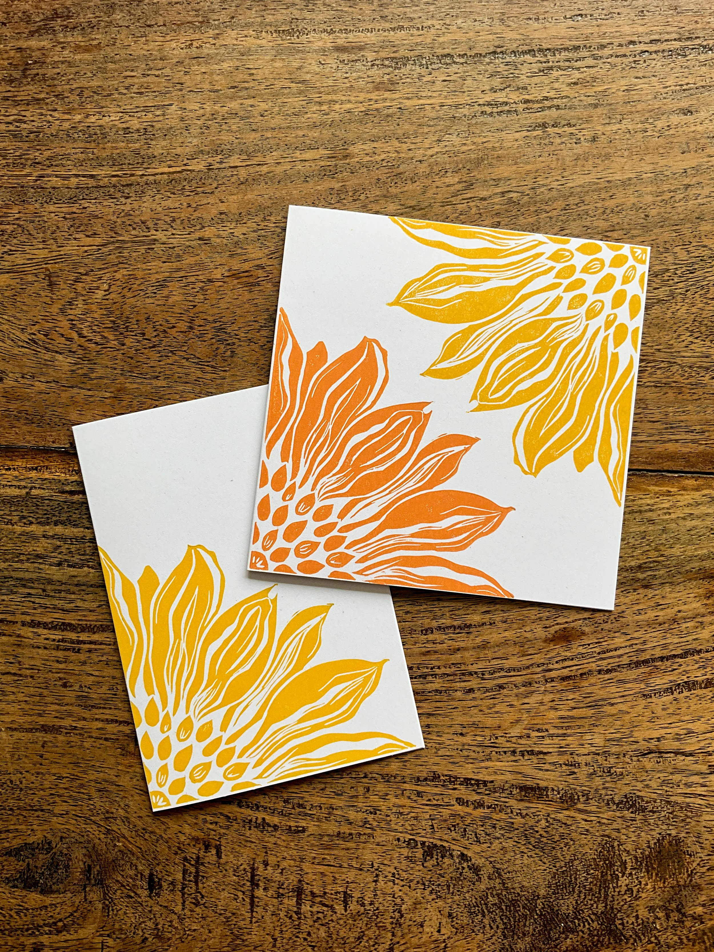 Photo of two sunflower quarter linocut greeting cards, in the two available sizes - A6 and square