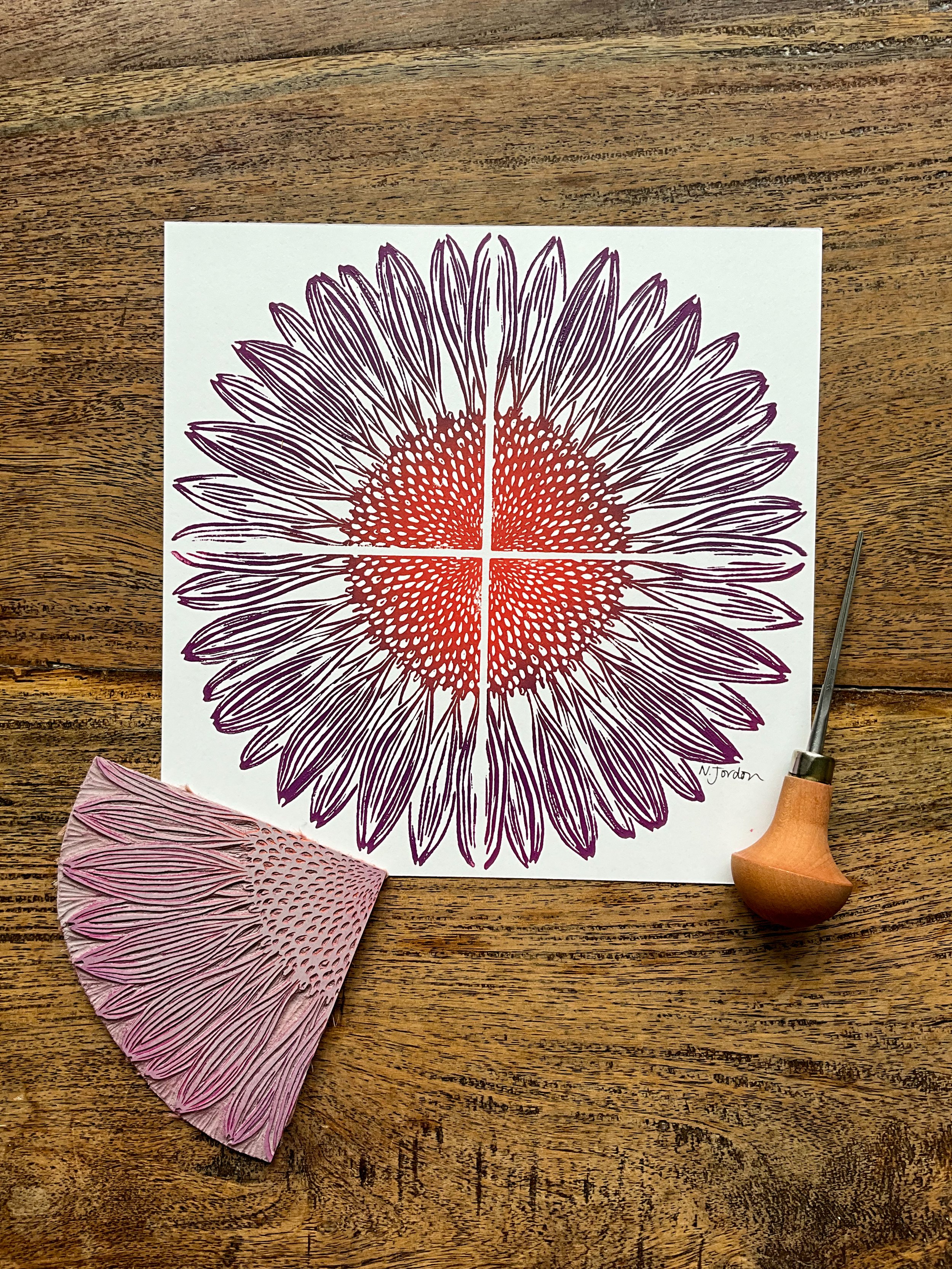 Single full coneflower linocut print, with quarter coneflower linocut block and carving tool. Printed with ombré of deep orange to deep purple