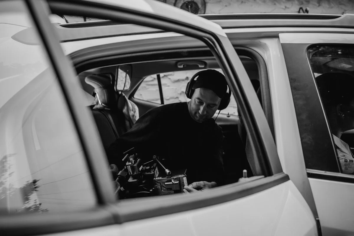 Ben Harrison behind the scenes setting up a camera rig in a car for a shoot
