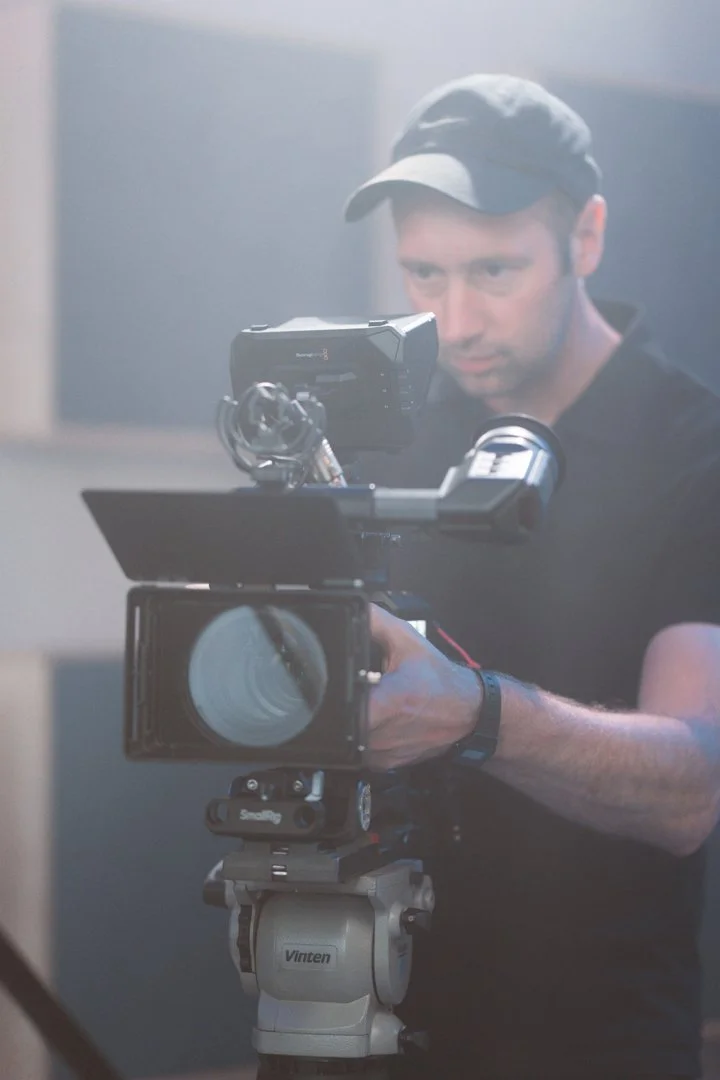 Ben Harrison filming with a professional video camera on set