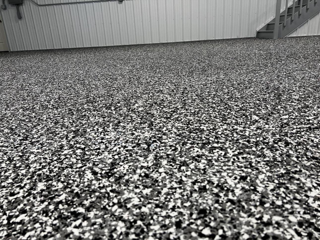 Epoxy flake garage floor with gray walls and staircase