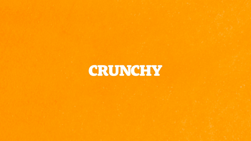 A bright orange background with the word 'CRUNCHY' written in bold white letters in the center.
