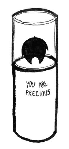 A black candle with a rounded flame inside a tall glass holder. The holder has a label that reads "You are precious."