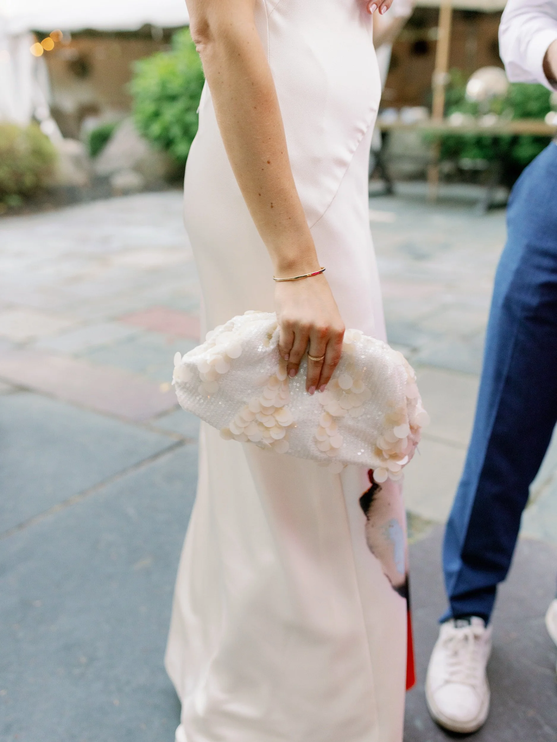 A newlywed holding a small white purse 