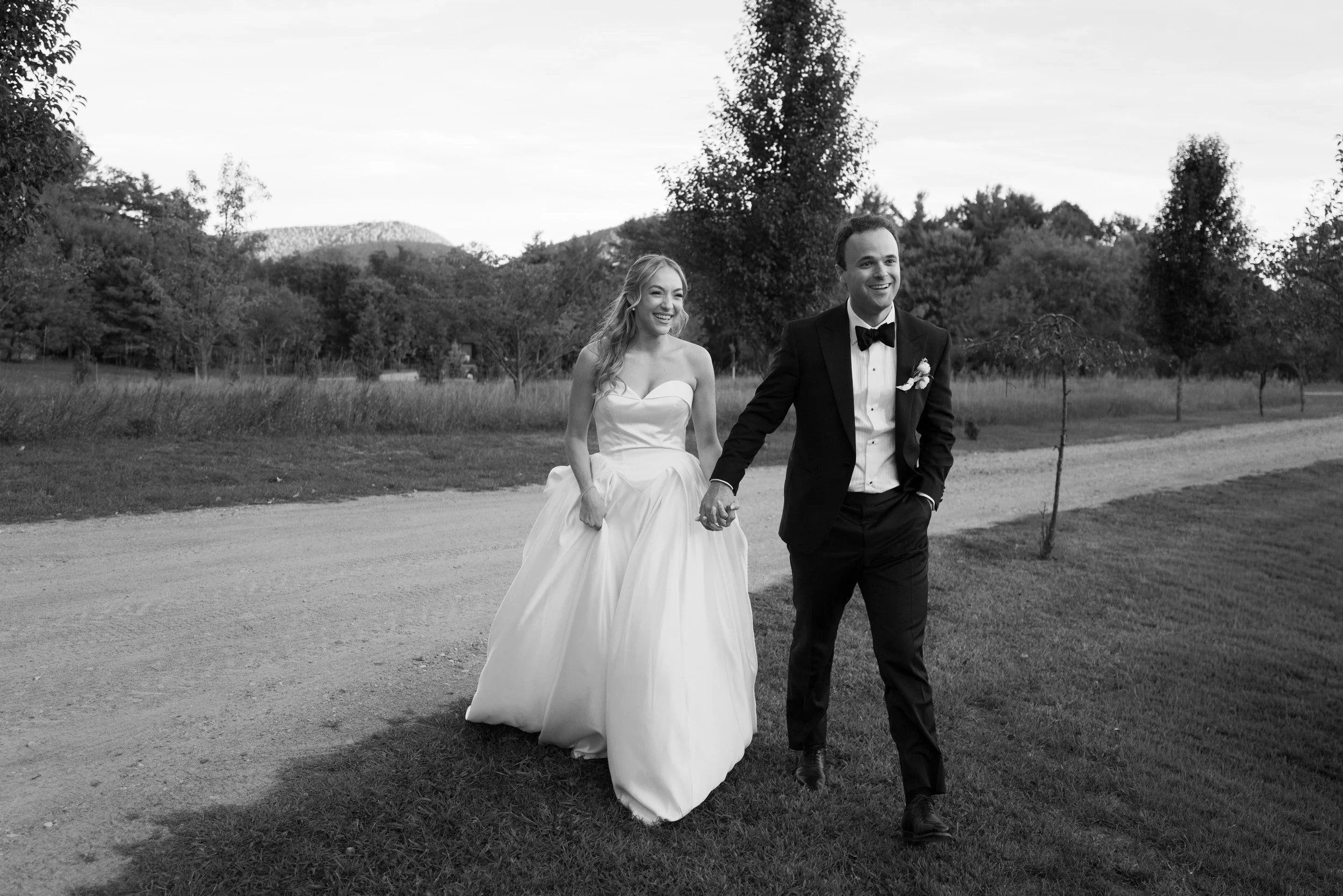 A newlywed couple holding hands and smiling together