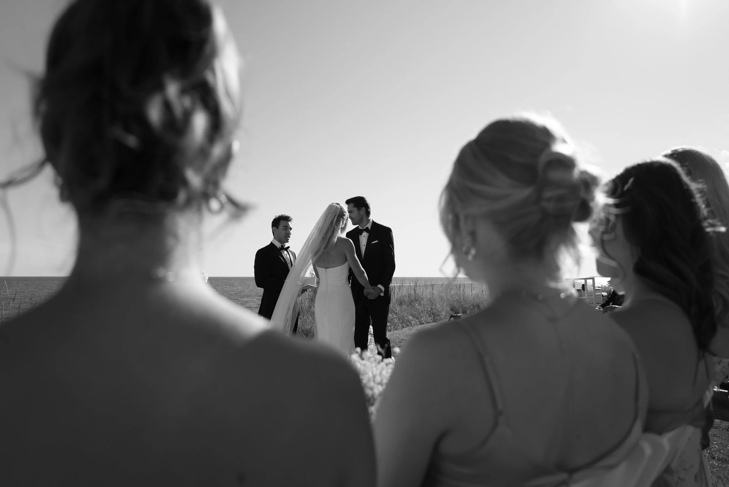 Newlyweds holding hands and guests look on during their wedding ceremony 