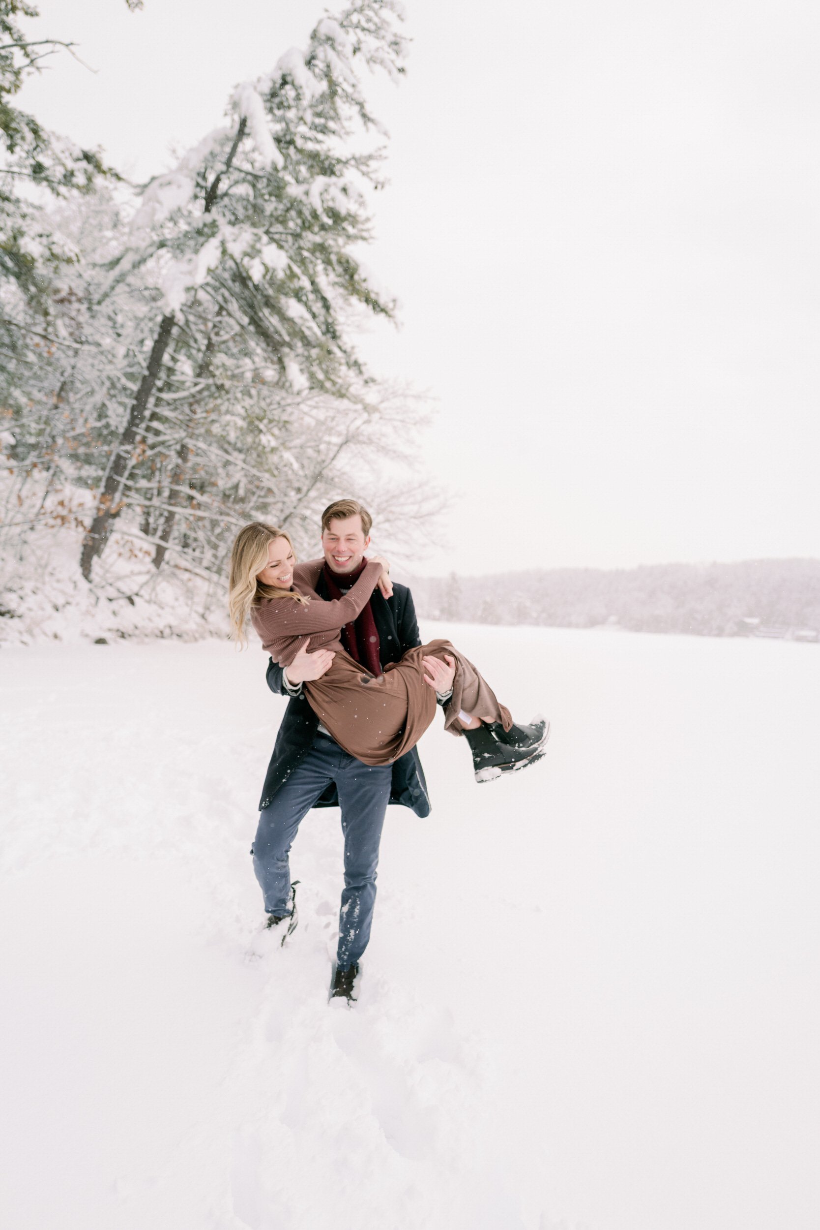 A person carrying their partner through the snow 