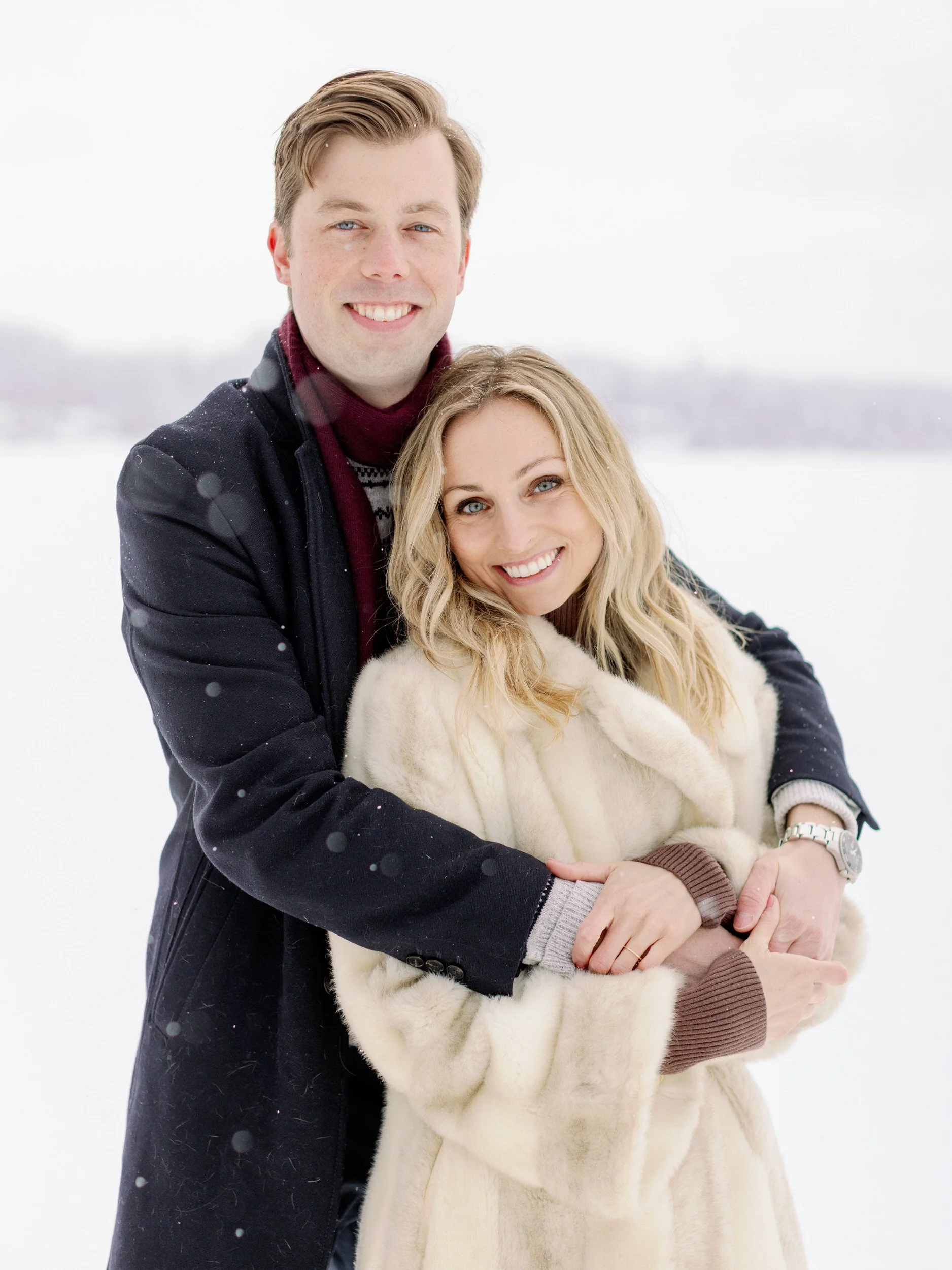 A person hugging their partner from behind as they smile 