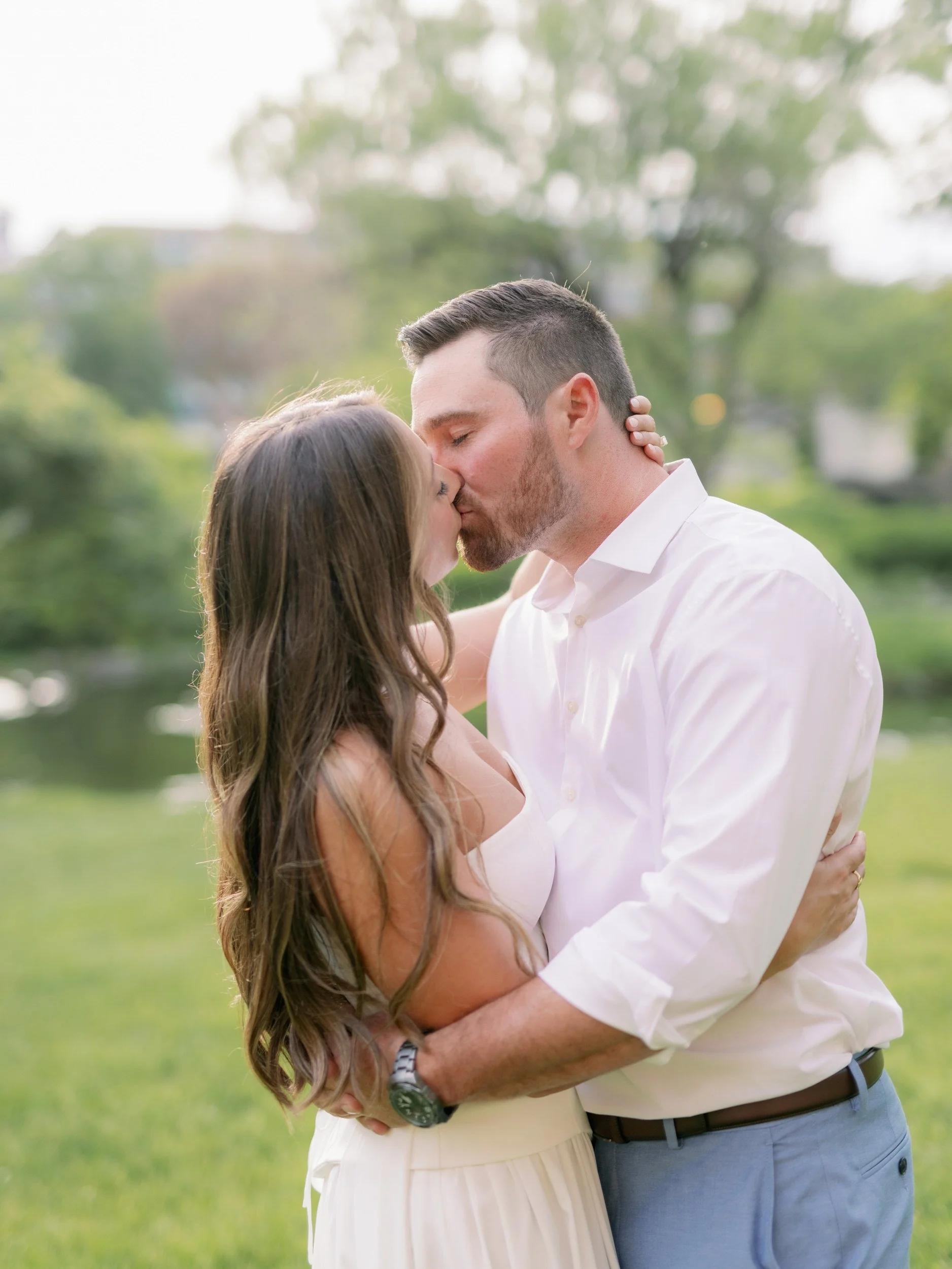 A couple with their arms around each other as they kiss