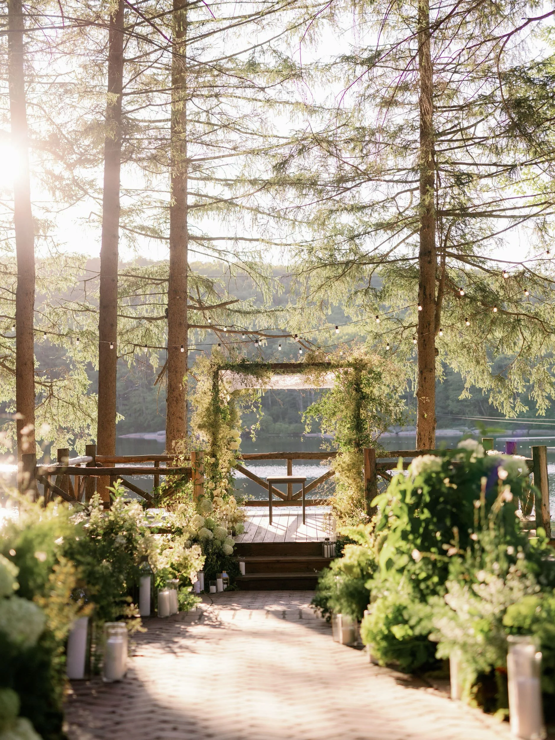  A wedding ceremony set up at the edge of a lake in the woods 