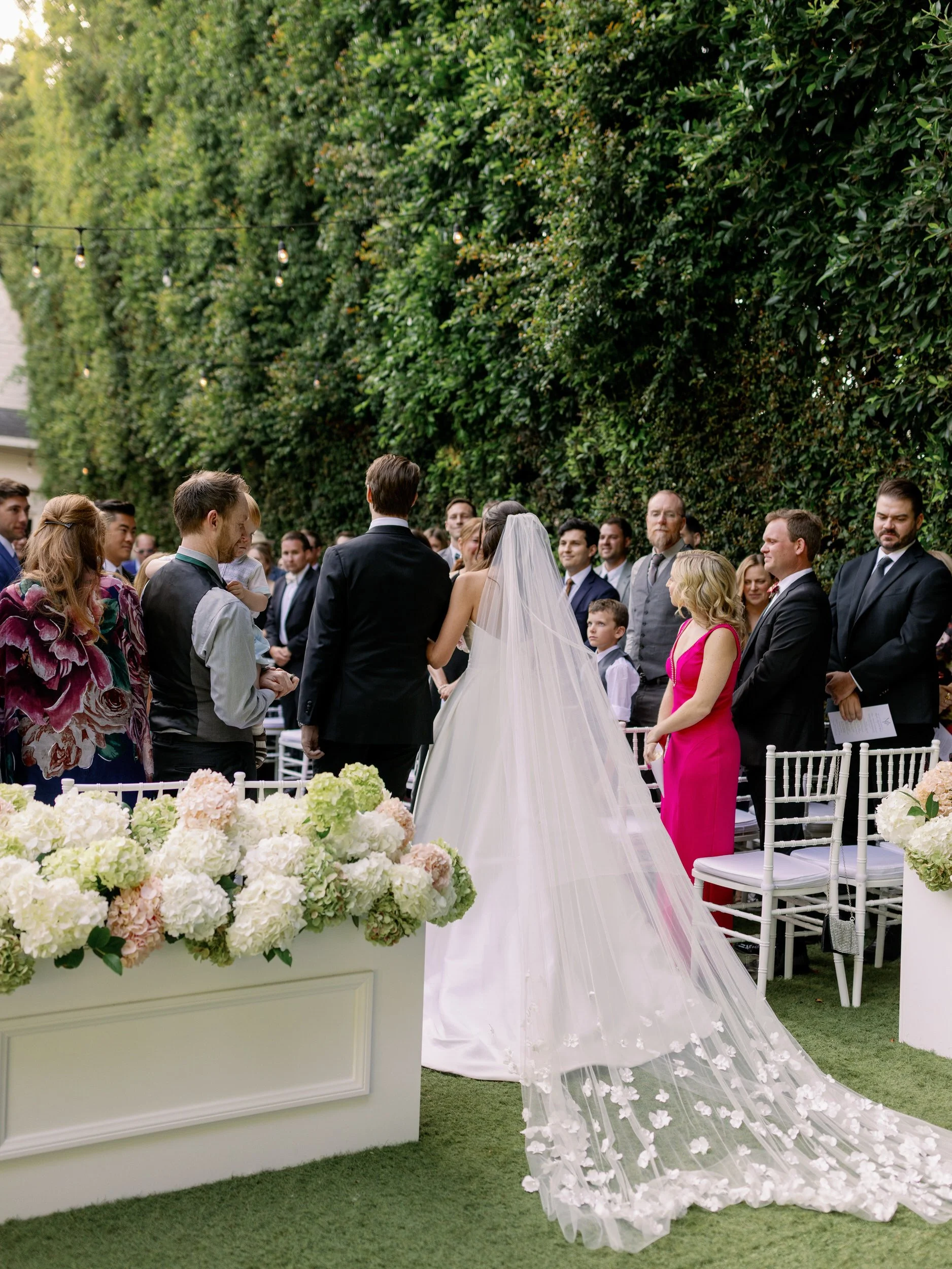 A person in a wedding dress walking down the aisle with a person in a suit next to them 