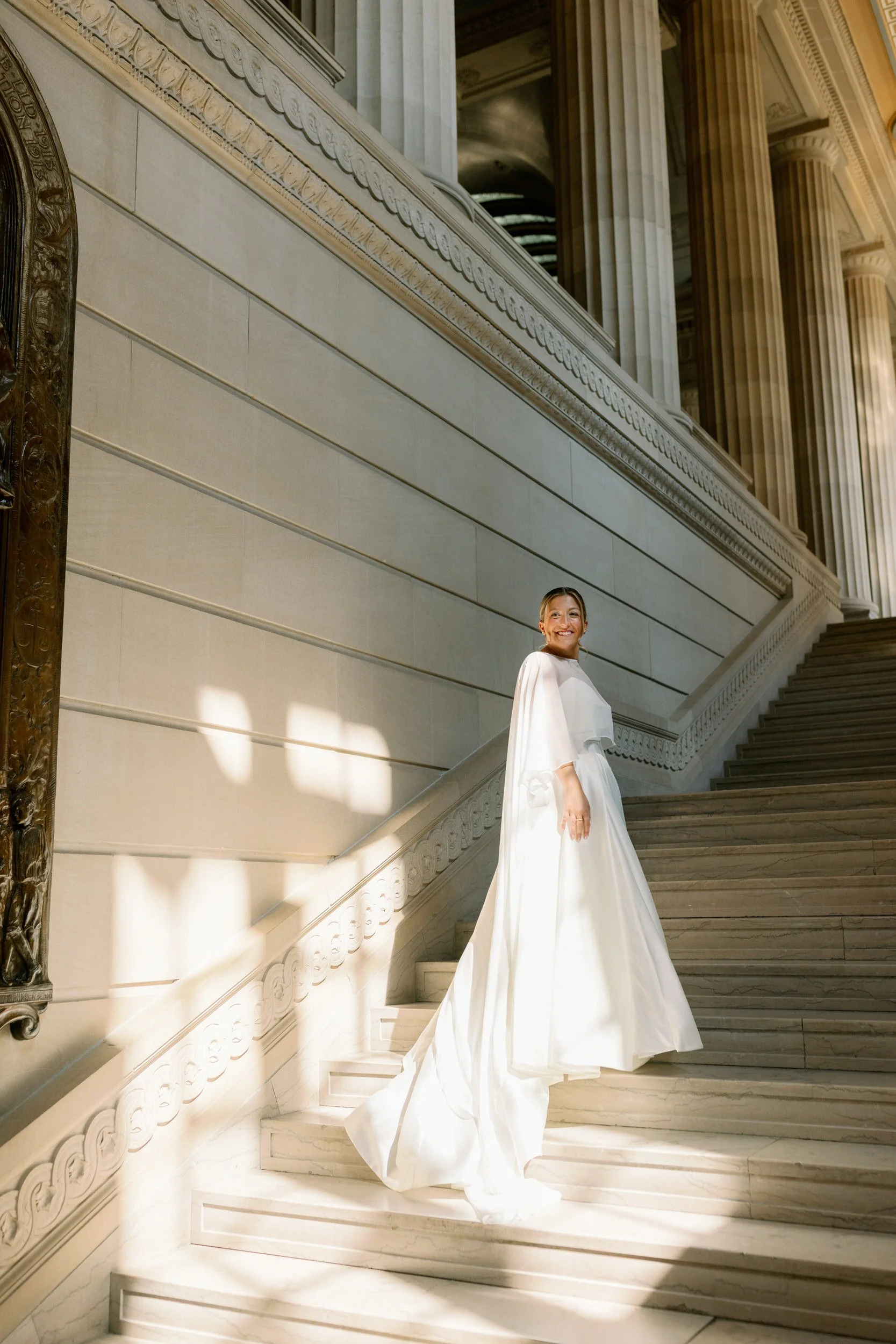 A person in a wedding dress standing on a staircase 