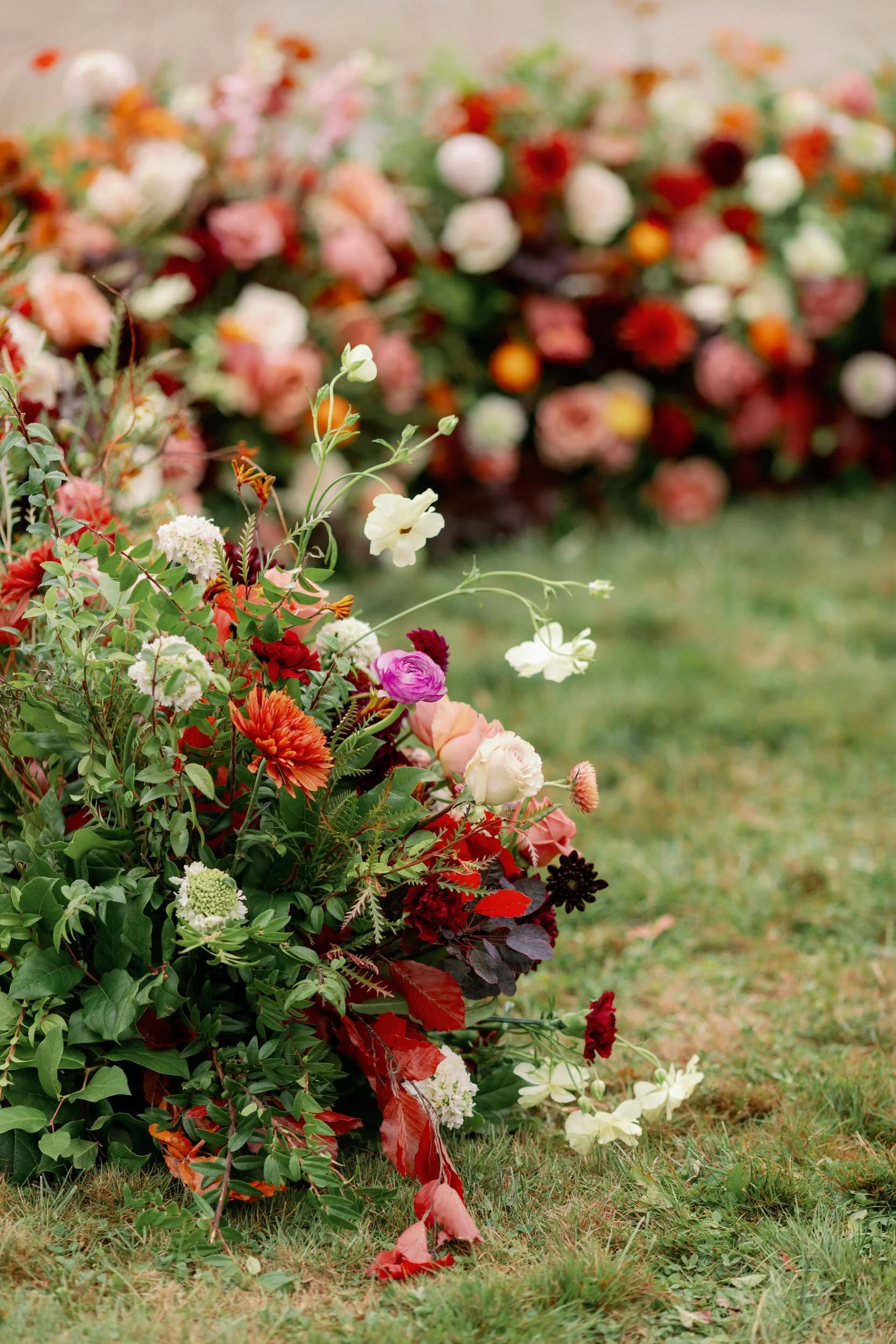 A large, colorful floral arrangement laying on the grass 