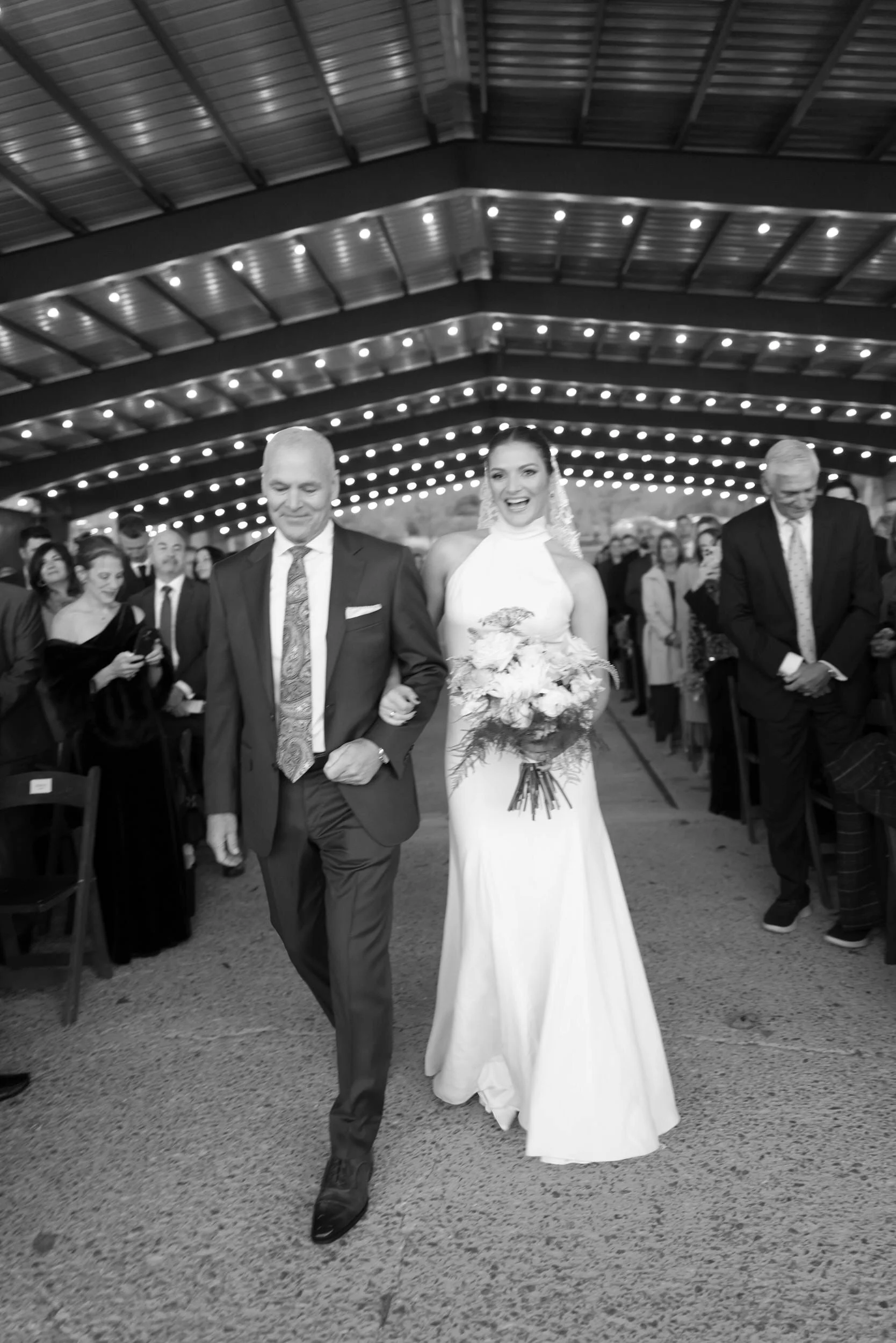 A person in a wedding dress being walked down the aisle before their wedding 