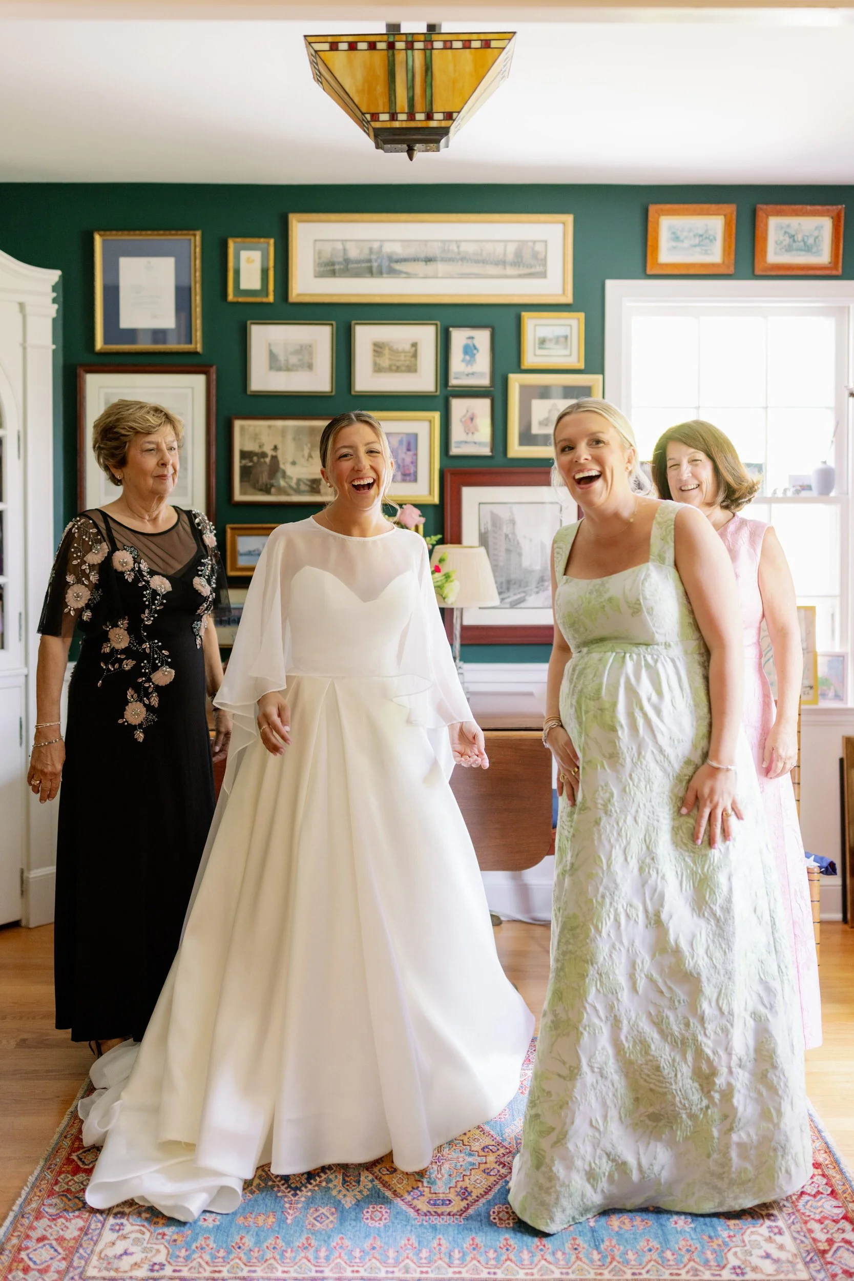 A person in a wedding dress laughing with their wedding party and family 