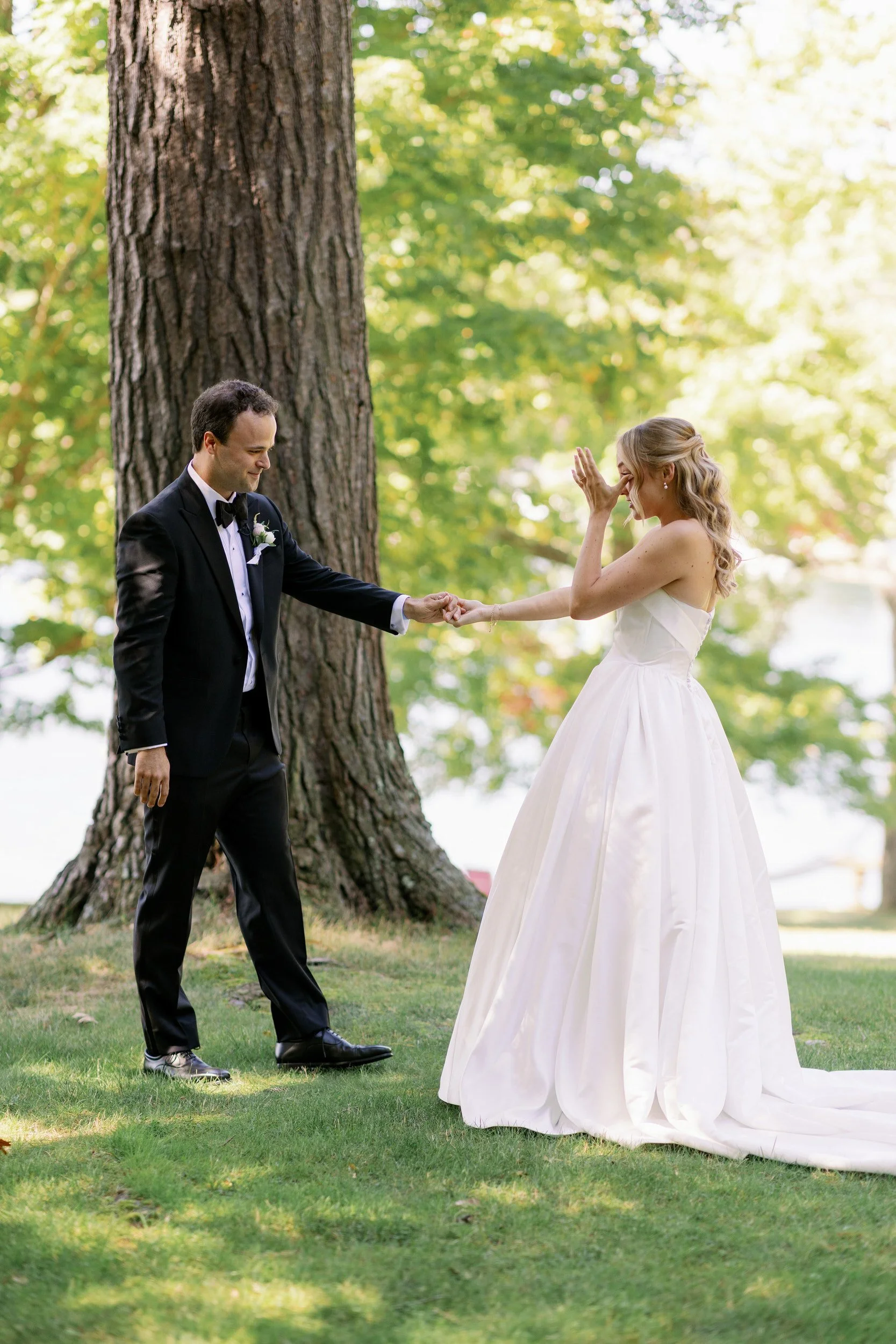 Newlyweds holding hands and smiling at each other during their first look