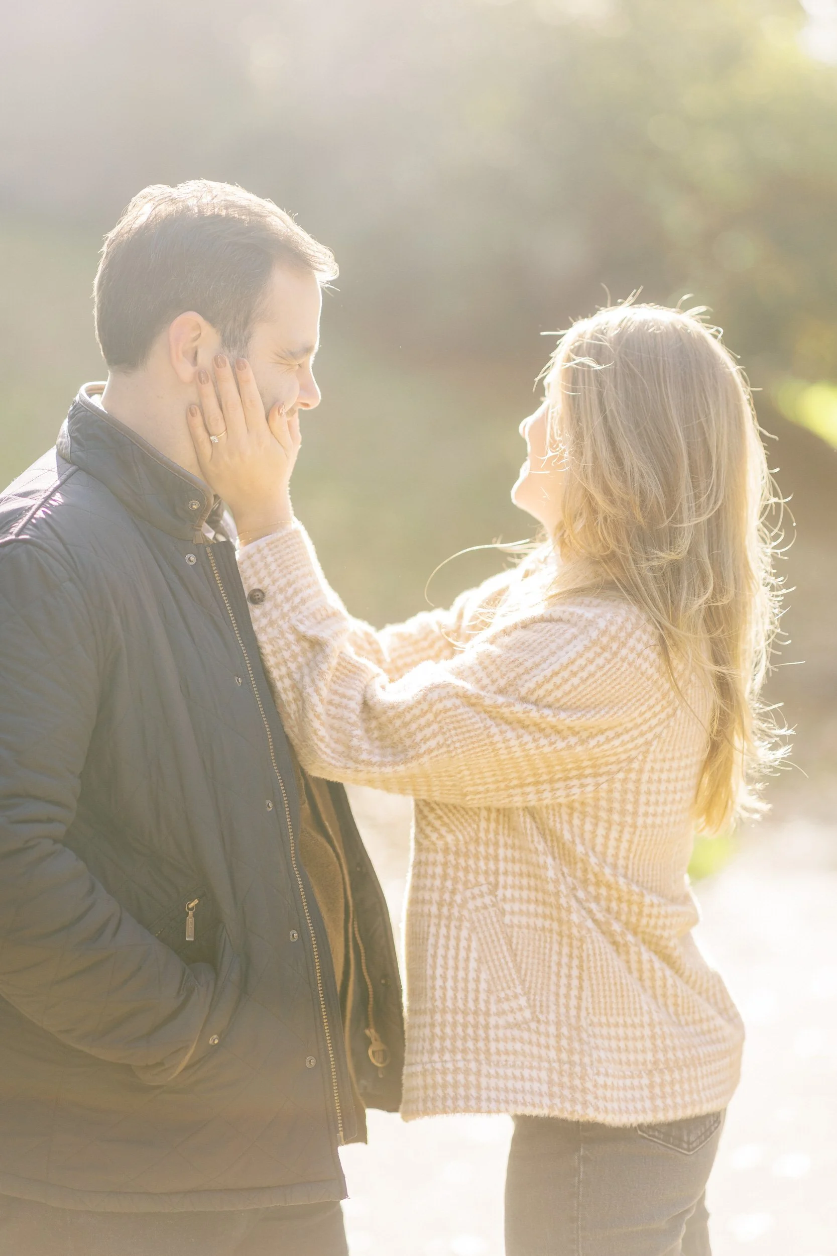 A person smiling and reaching up to their partner's face