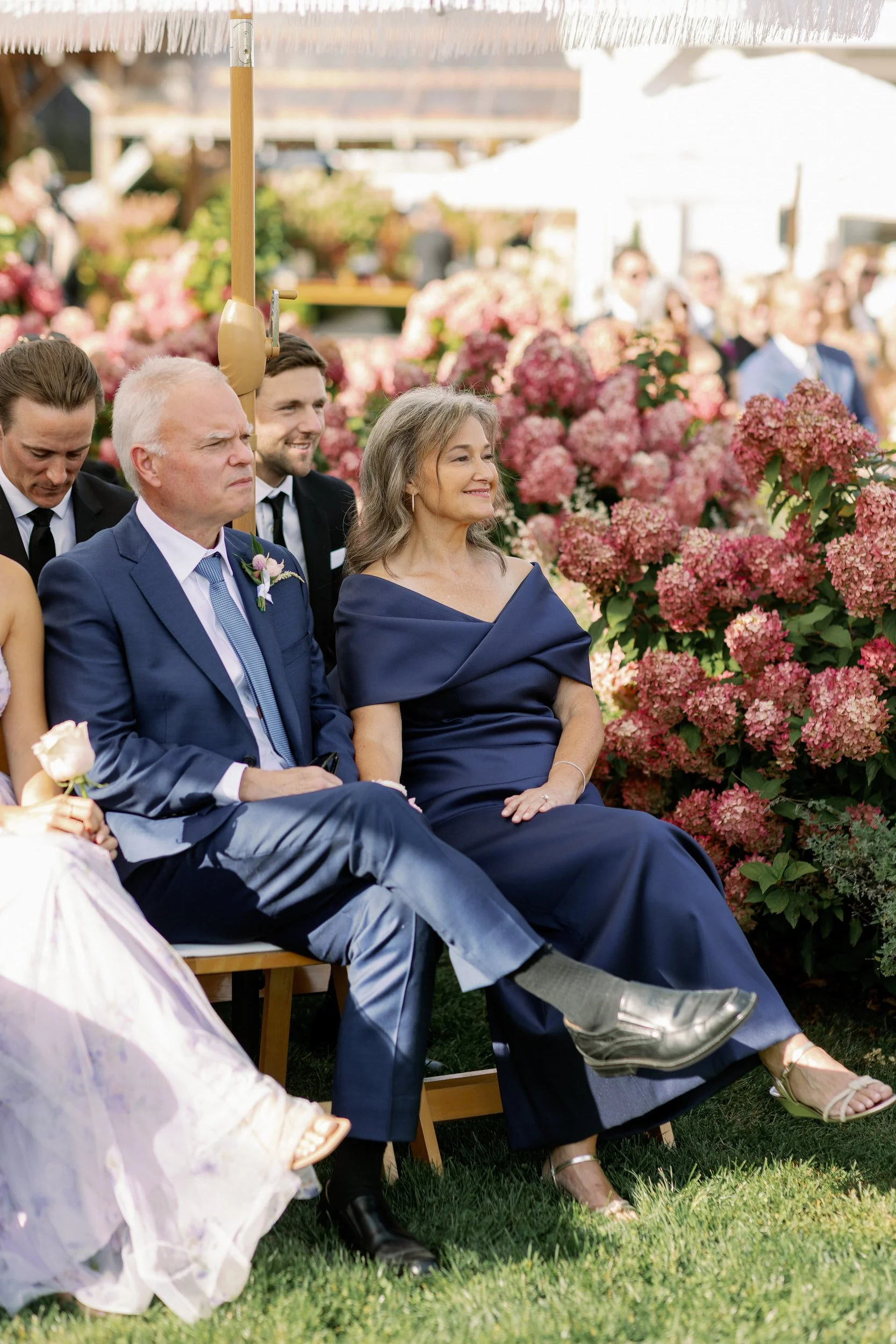 An older couple sitting in chairs during a wedding ceremony 