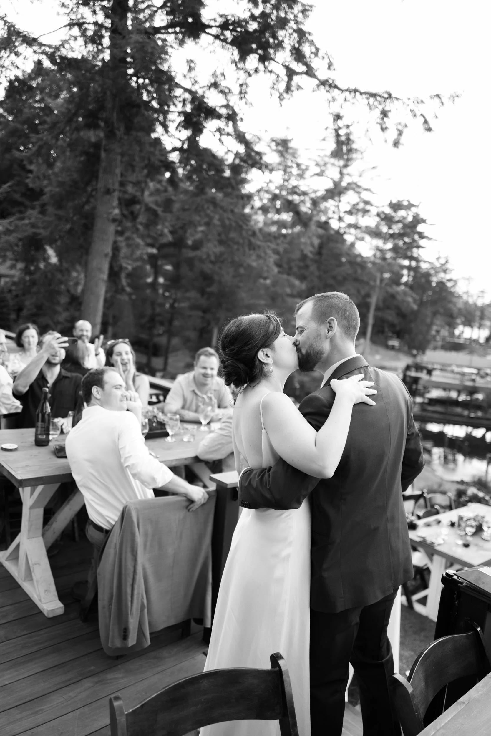 A newlywed couple kissing at their reception 