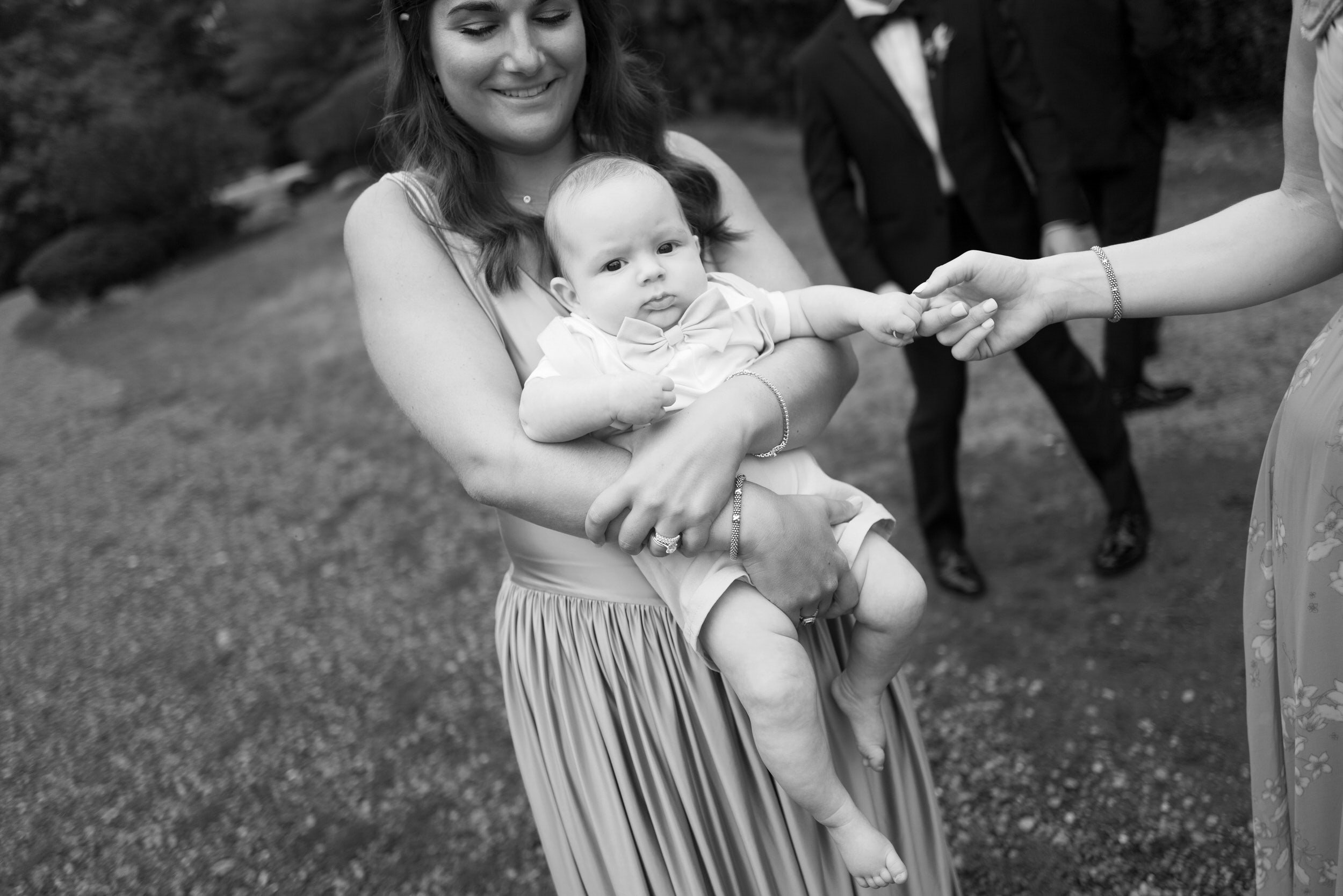 A person smiling and holding a small baby 