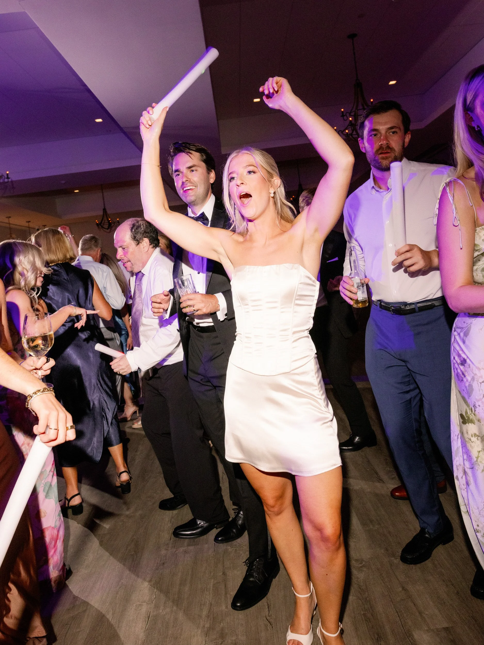Newlyweds dancing with wedding guests at their reception 