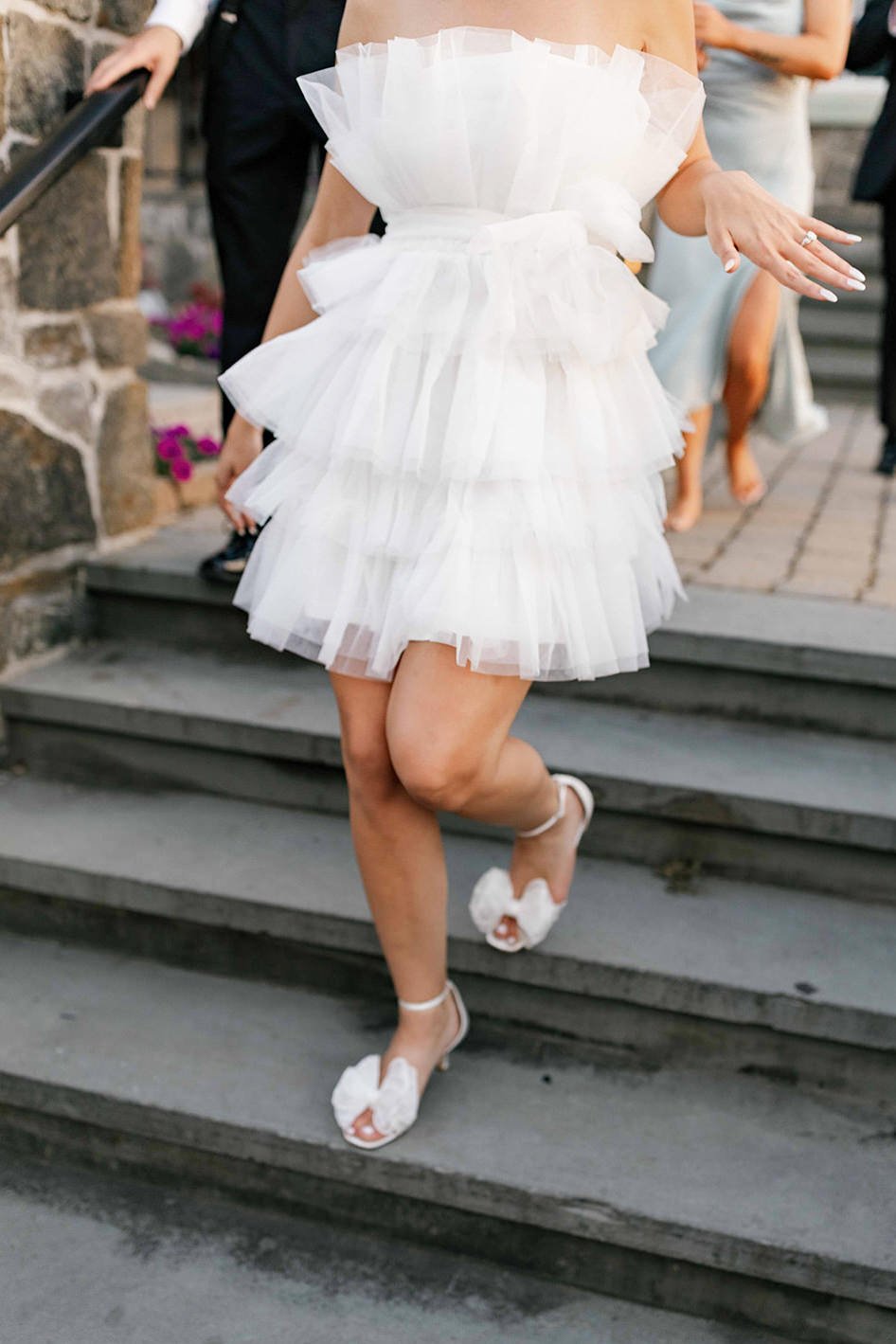 A person in a short white dress walking down a staircase 