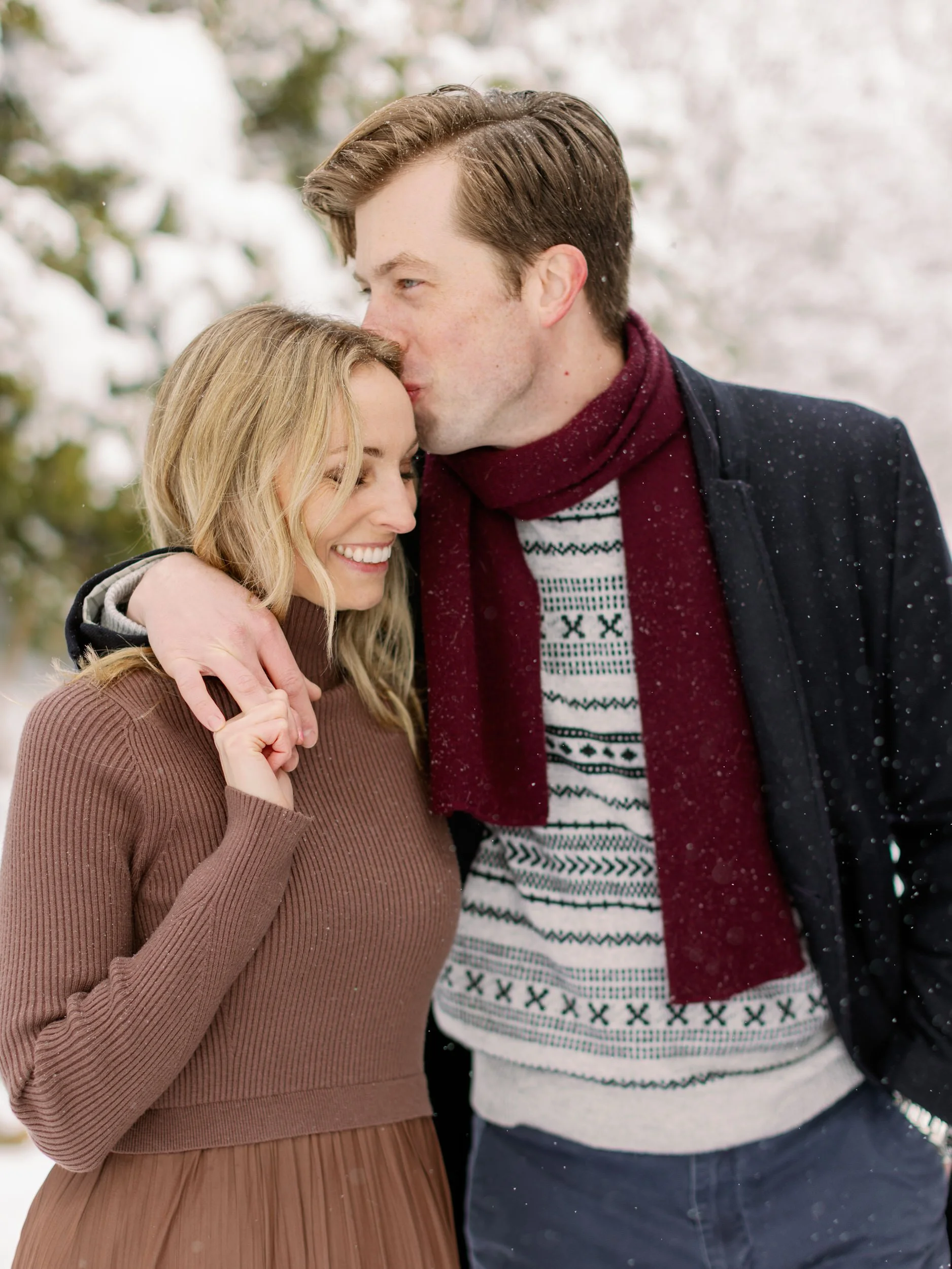 A person kissing their partner's cheek with their arm over their shoulder