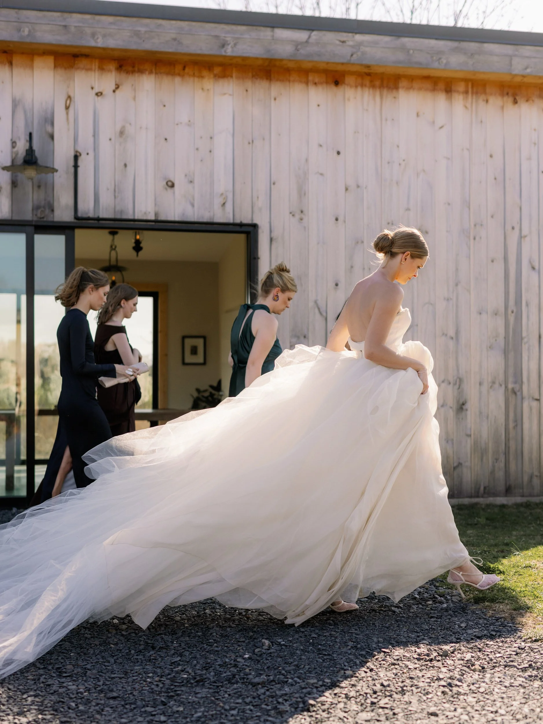 A newlywed in a dress walking with their wedding party