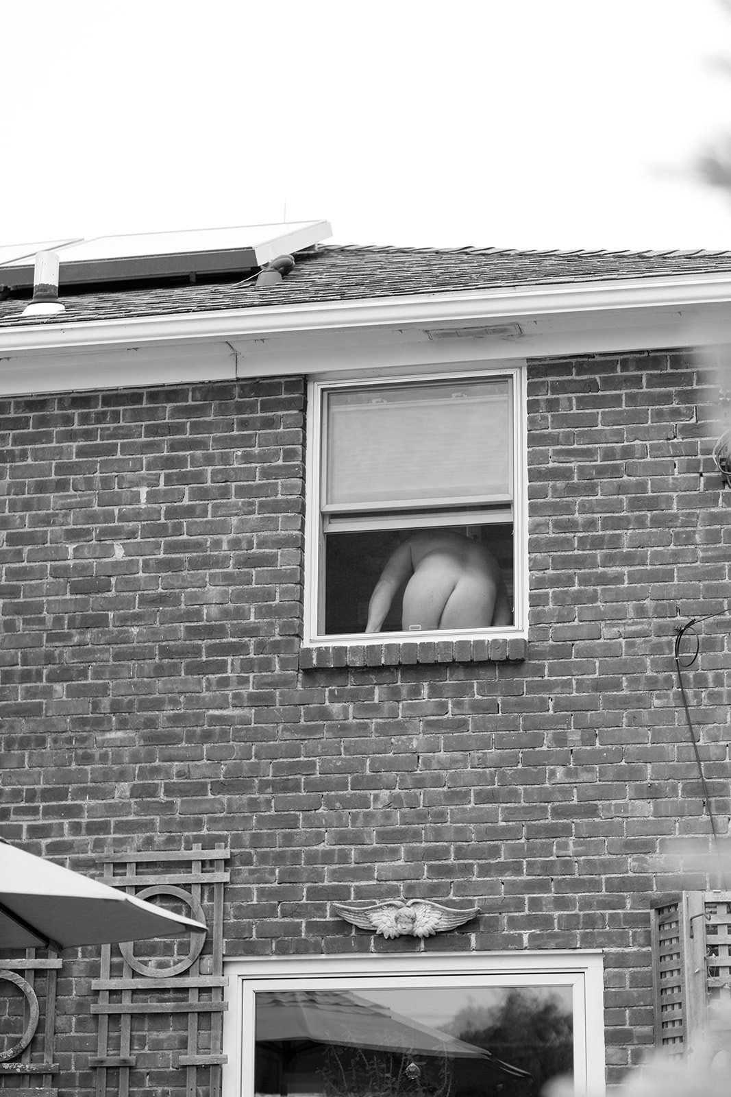 A bare butt sticking out of a window
