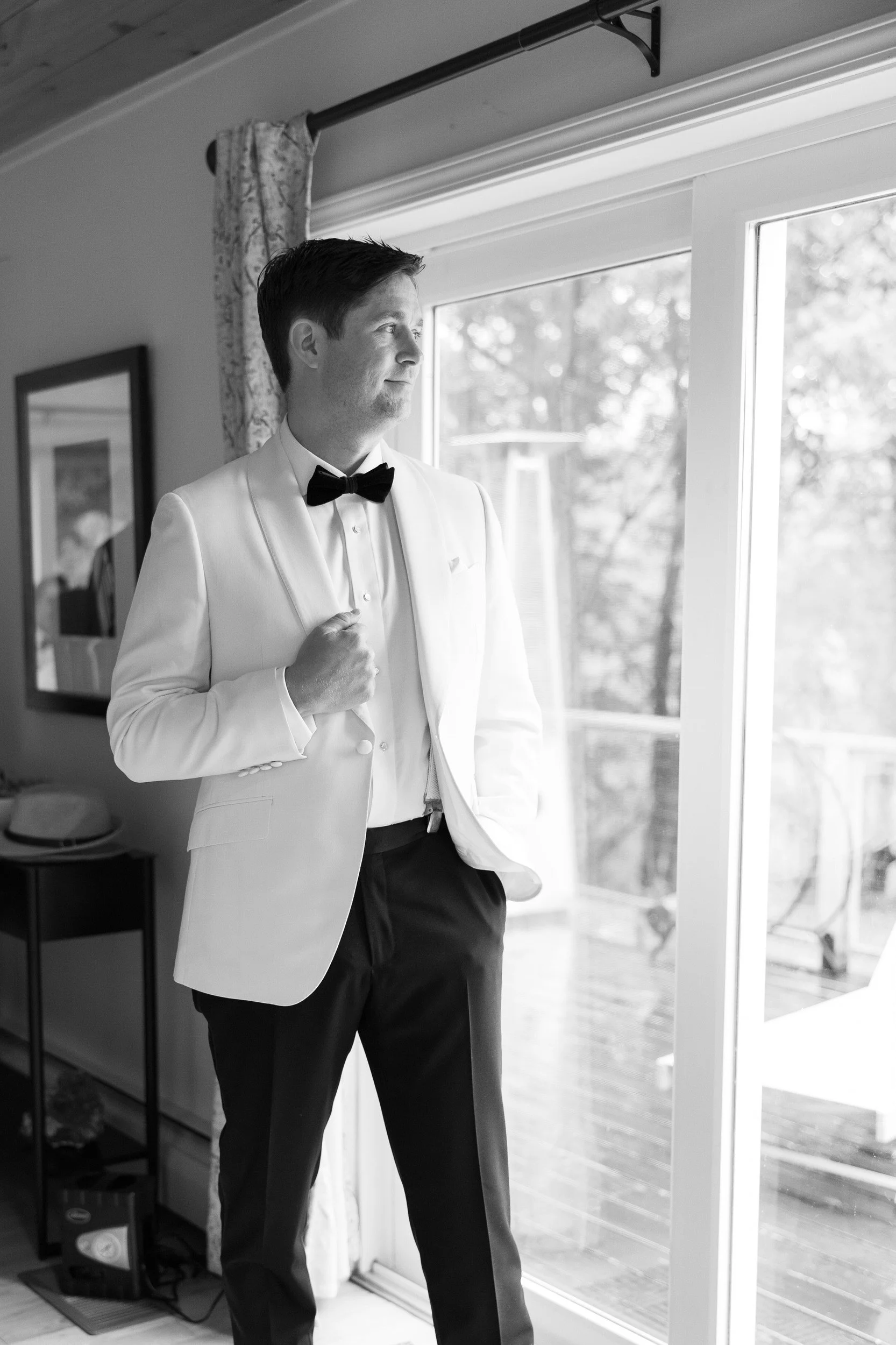 A person in a white suit looking out a window 
