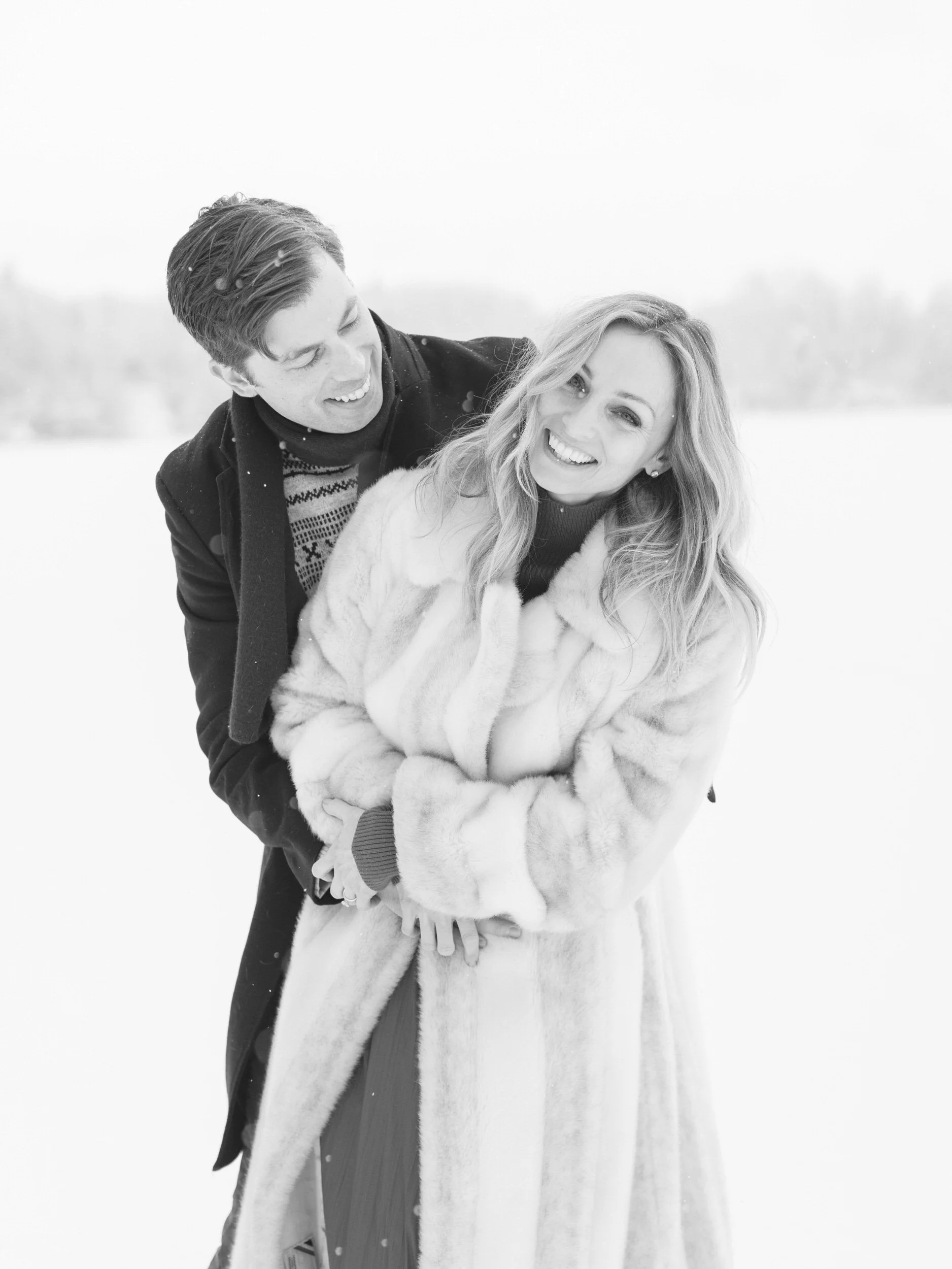 A person hugging their partner from behind and looking over their shoulder at them 