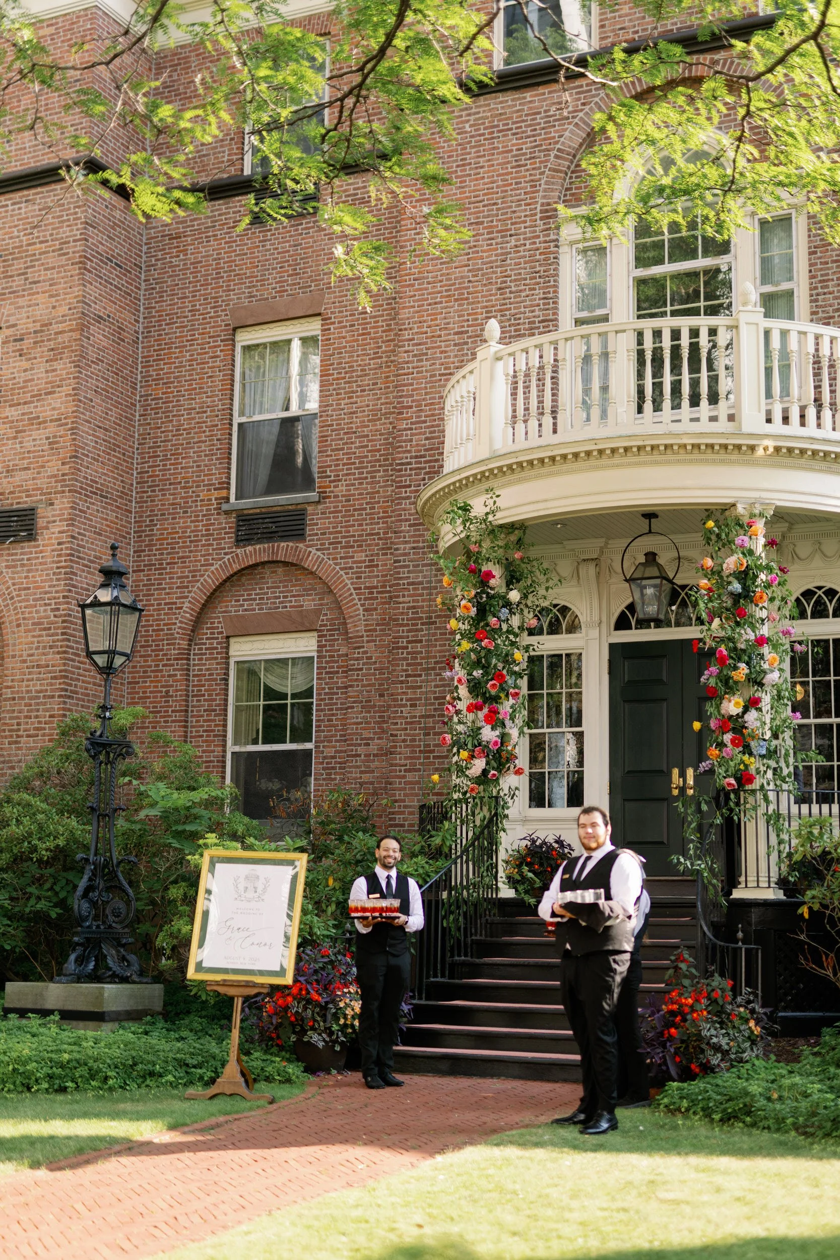 Two people in suits standing outside a wedding venue 