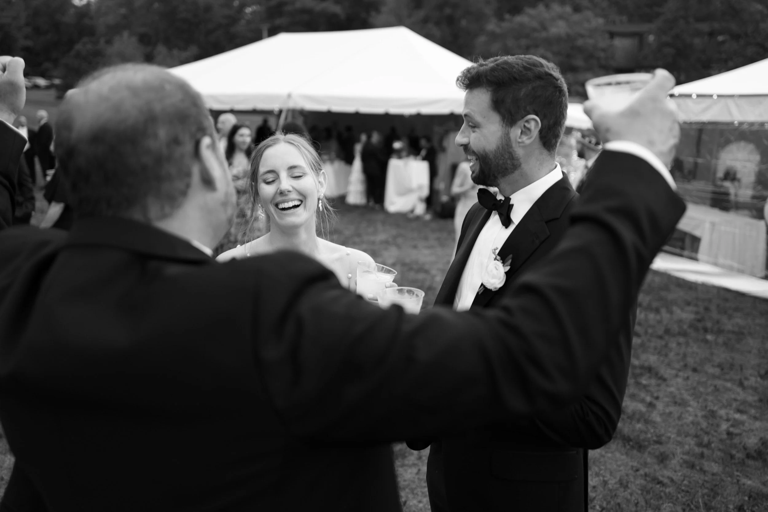 Wedding guests laughing and toasting at a reception 