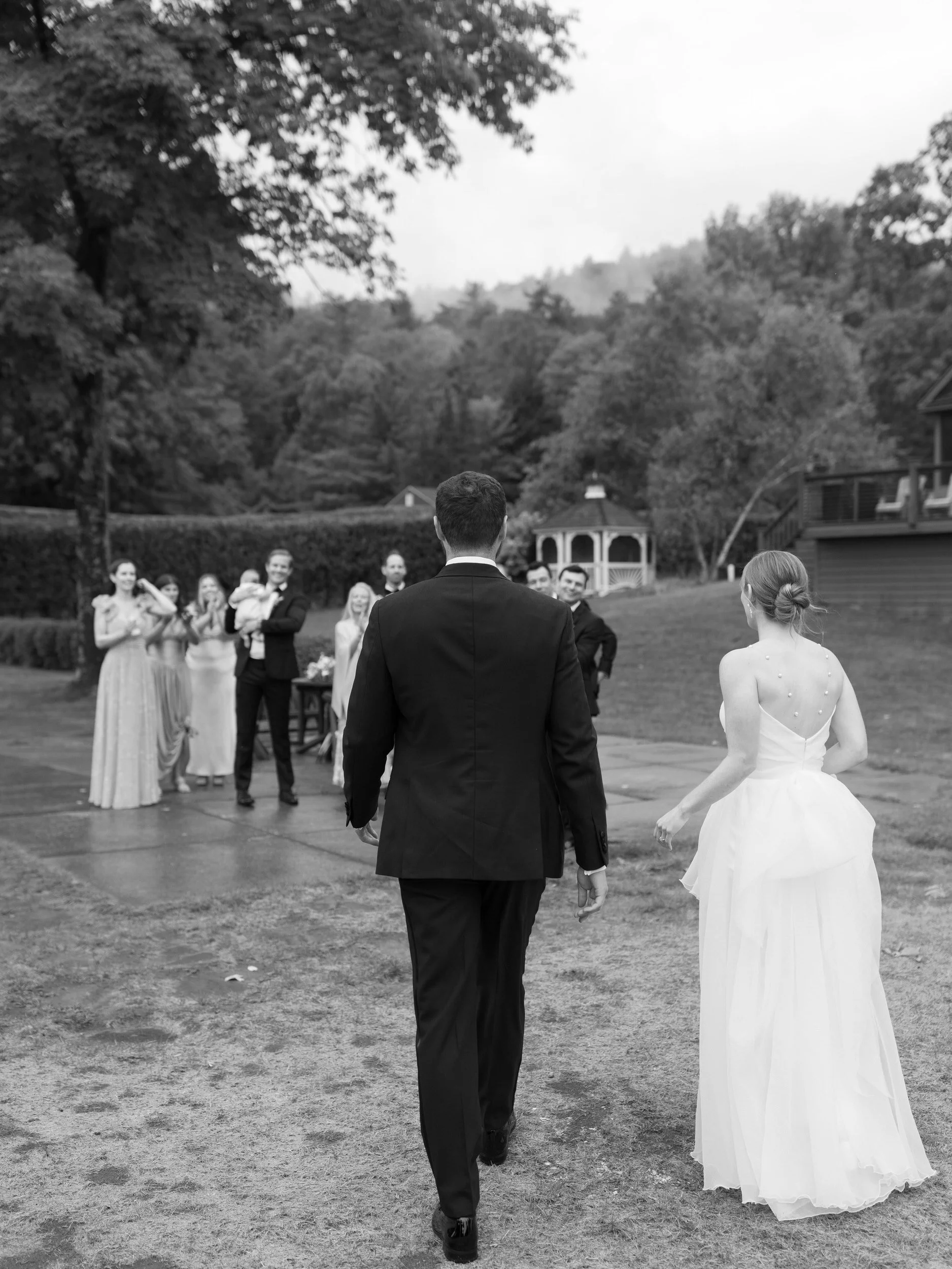 Newlyweds walking towards their wedding parties 