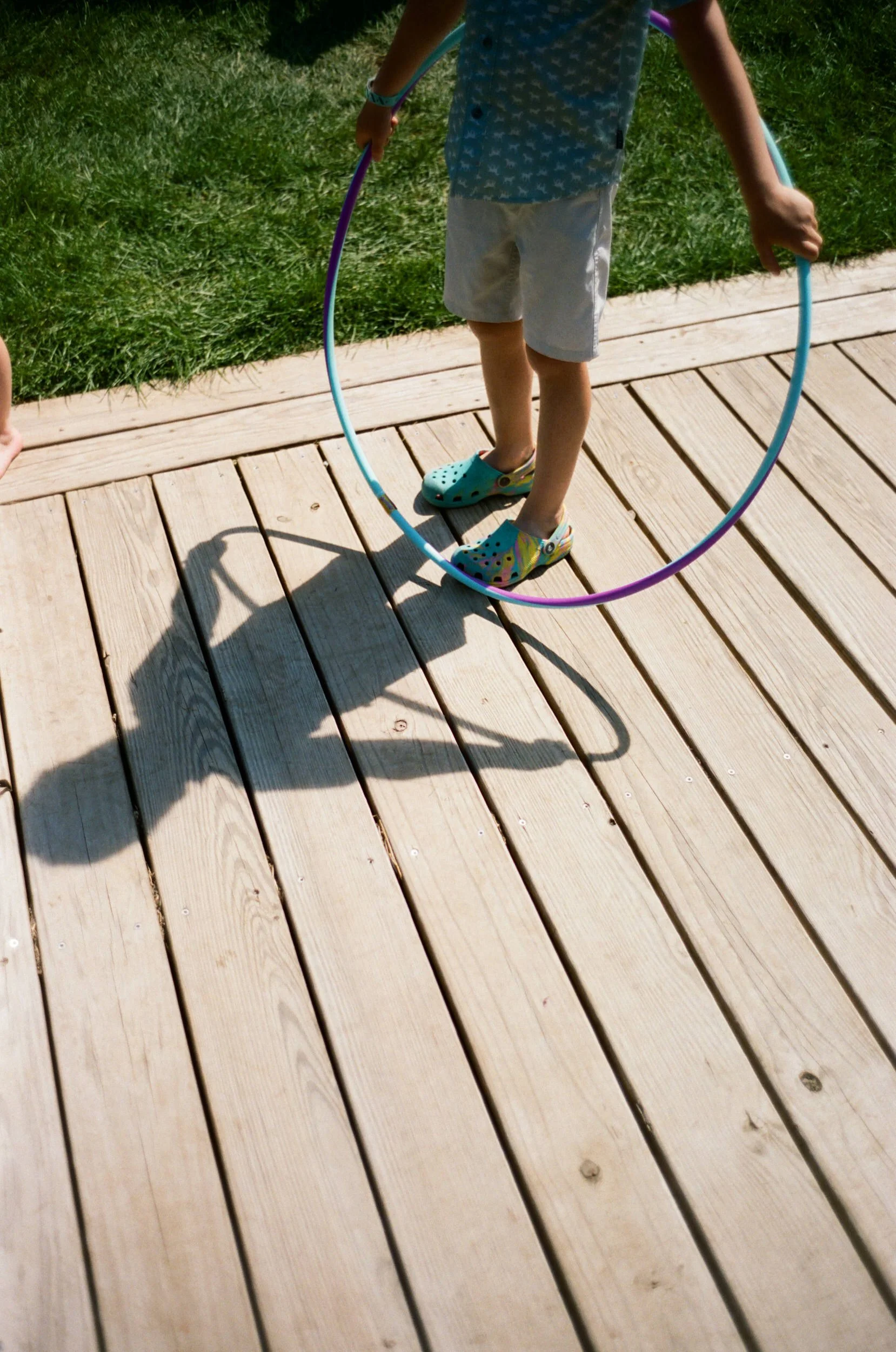 A small child jumping through a hula hoop 