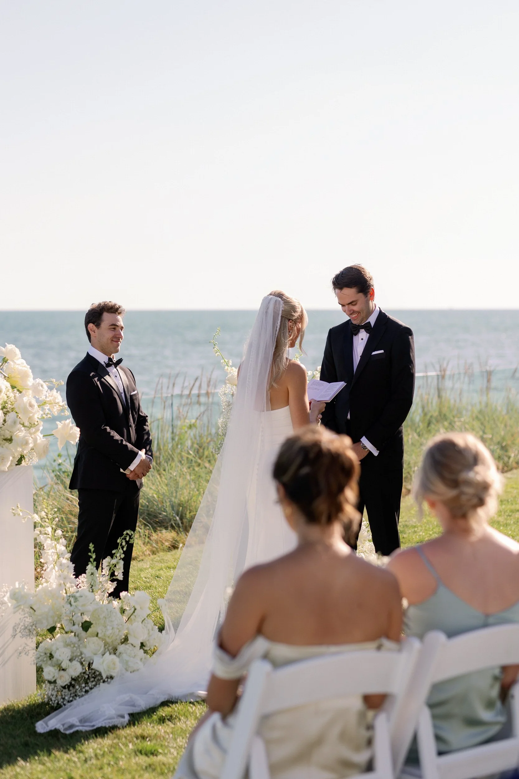 Newlyweds holding hands and laughing as they say their vows
