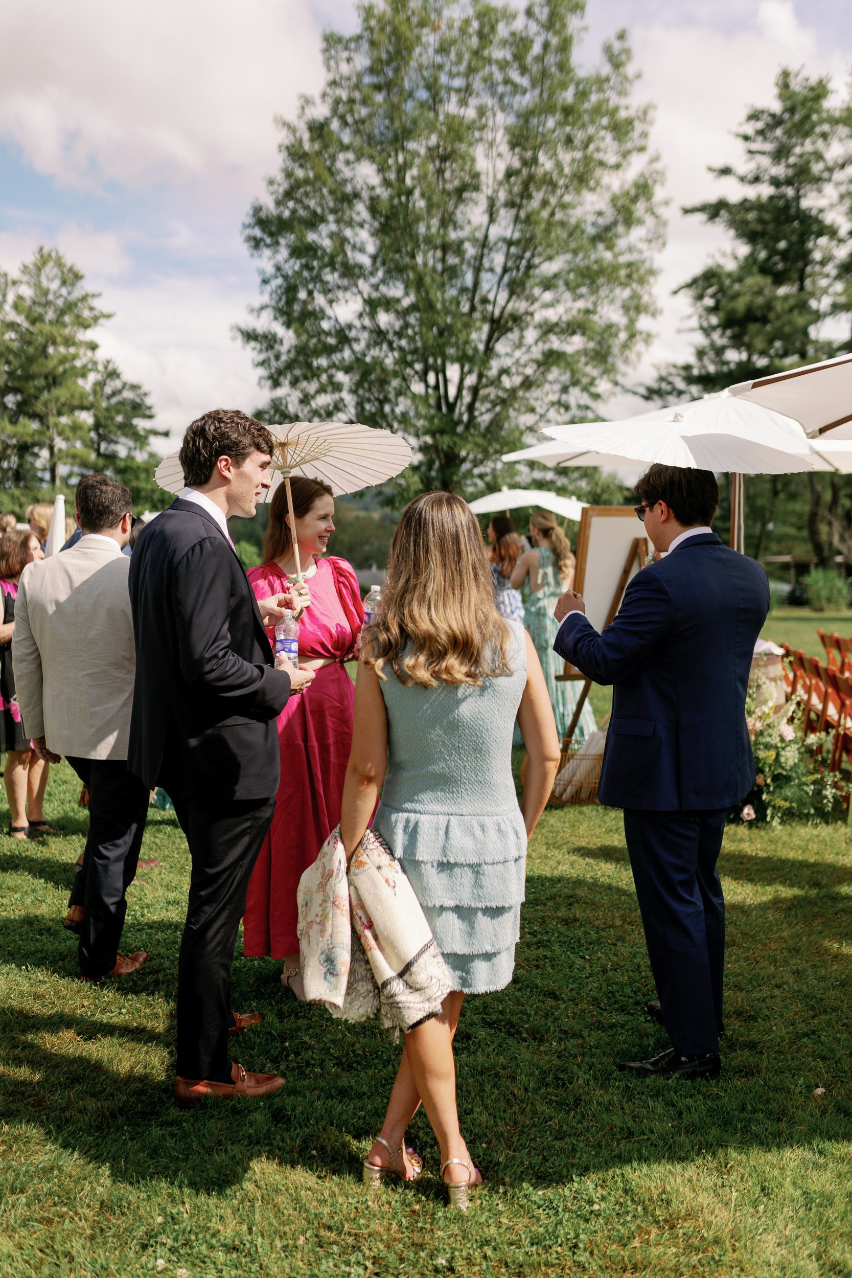 Wedding guests mingling during a cocktail hour on a lawn