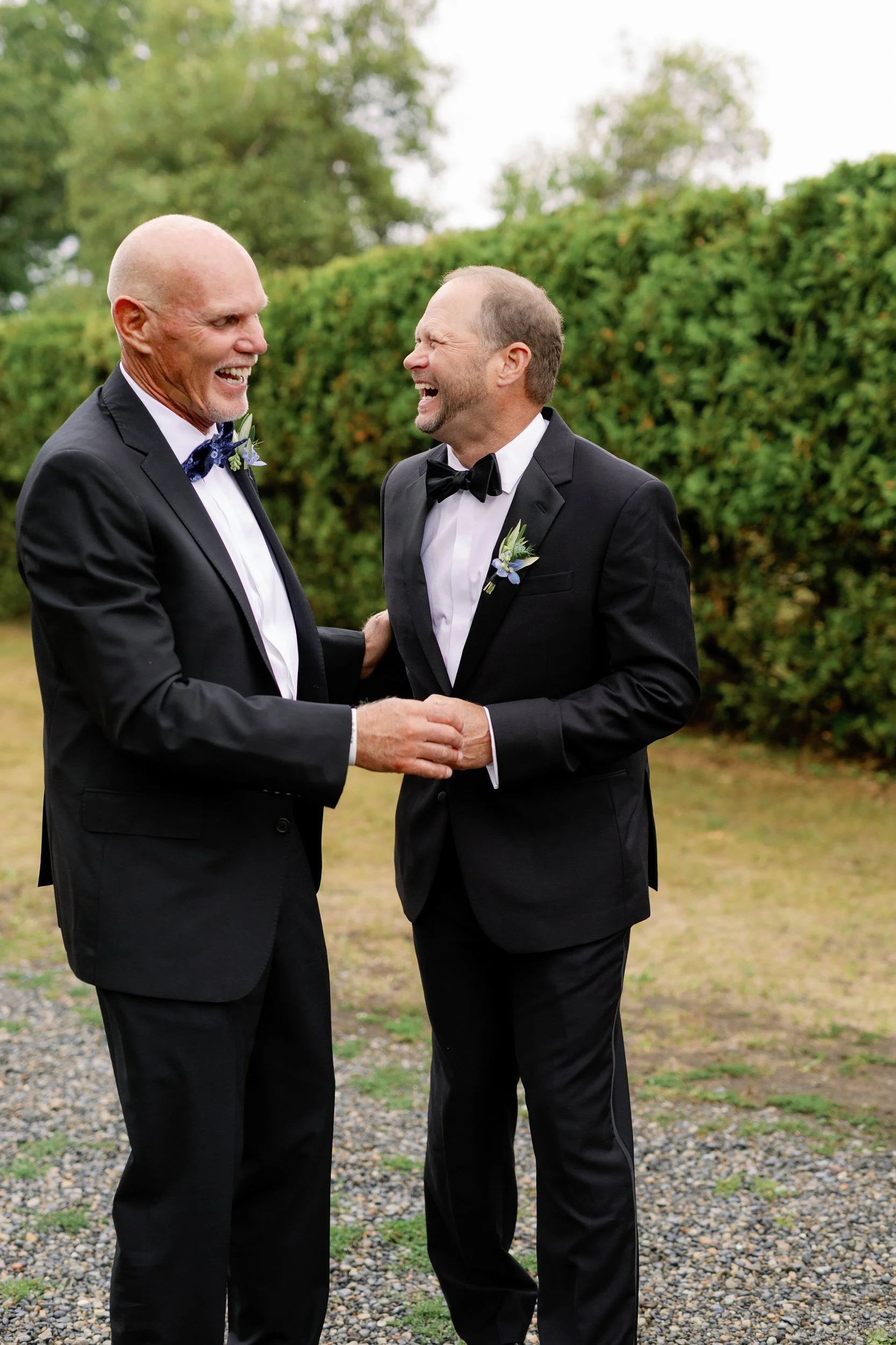 Two people in suits laughing together 