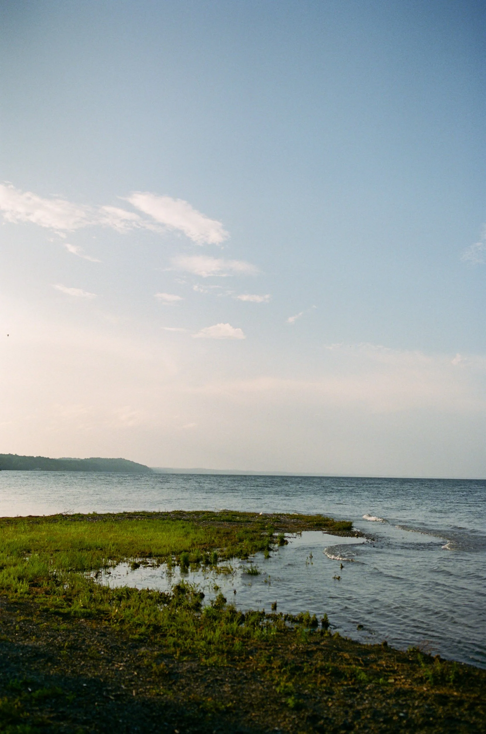 A grassy area at the foot of a large lake