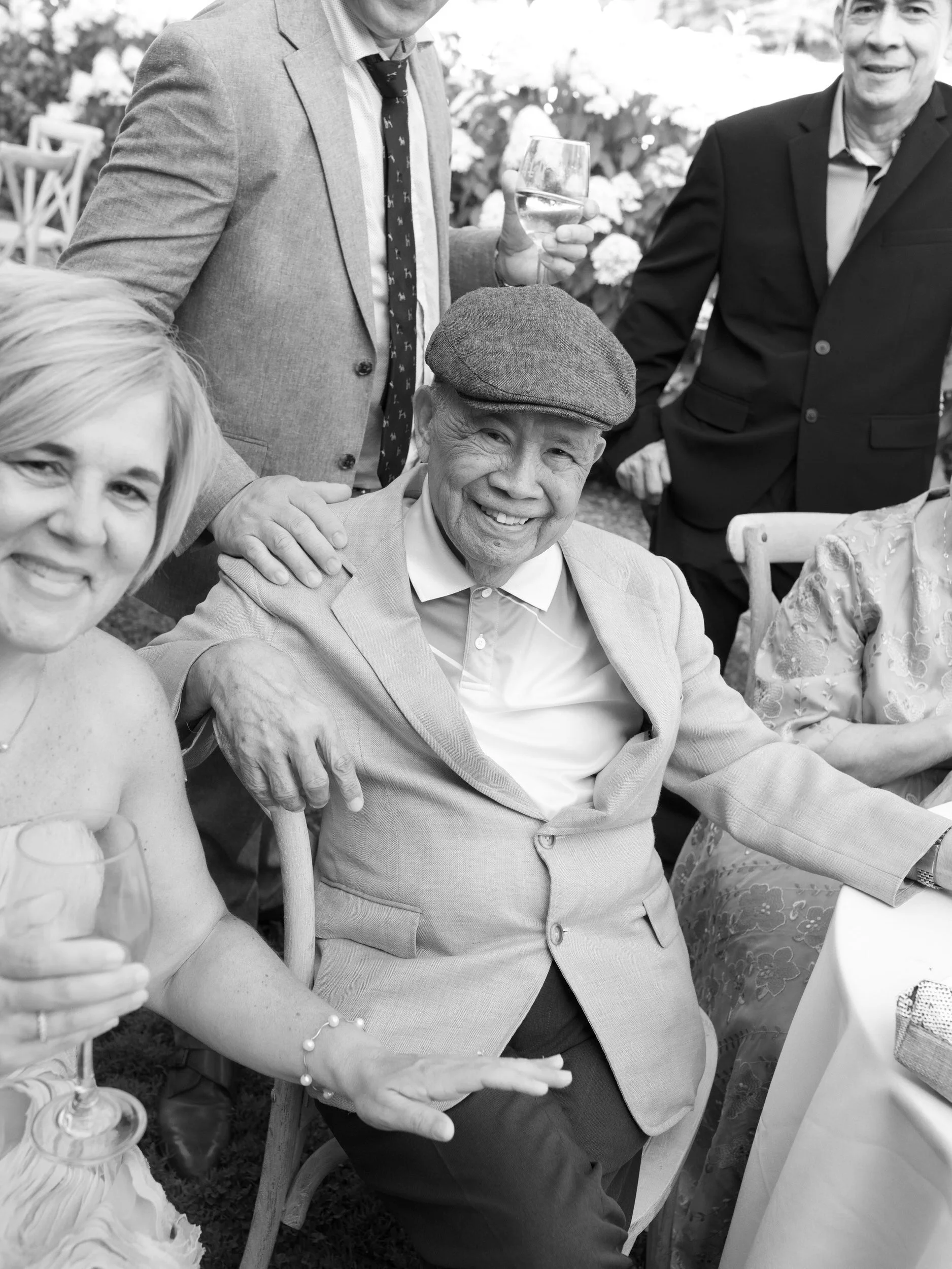  Older wedding guests sitting together at a reception and smiling  