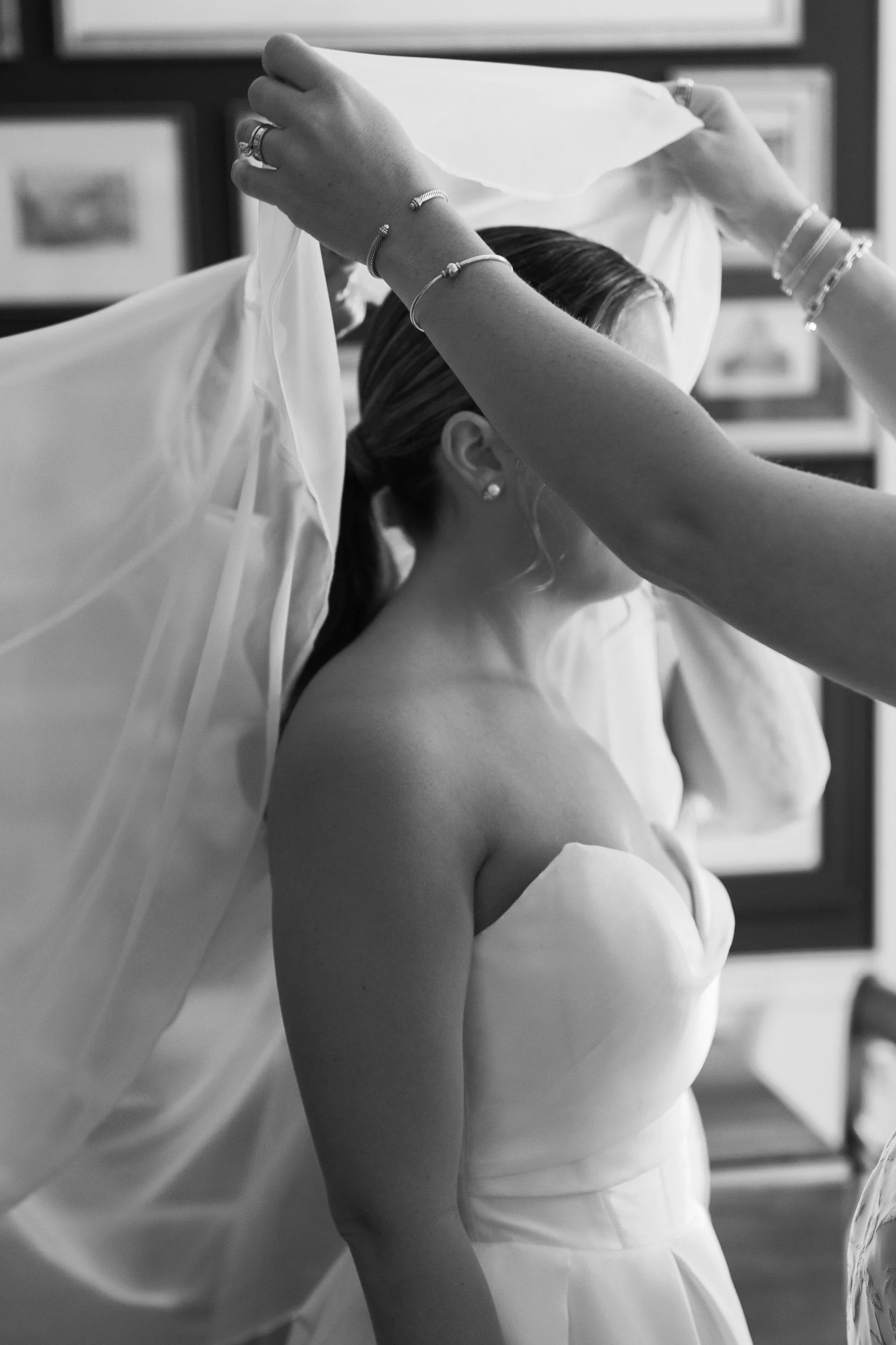 A person helping someone put on a wedding veil 