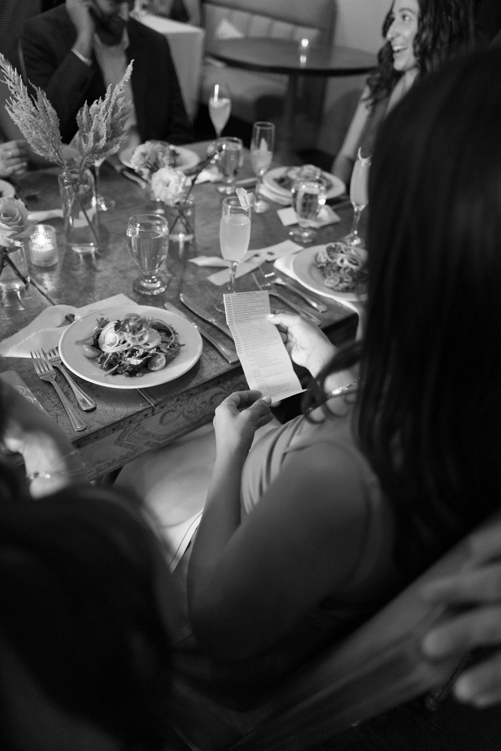 Guests sitting around a reception table reading notes 