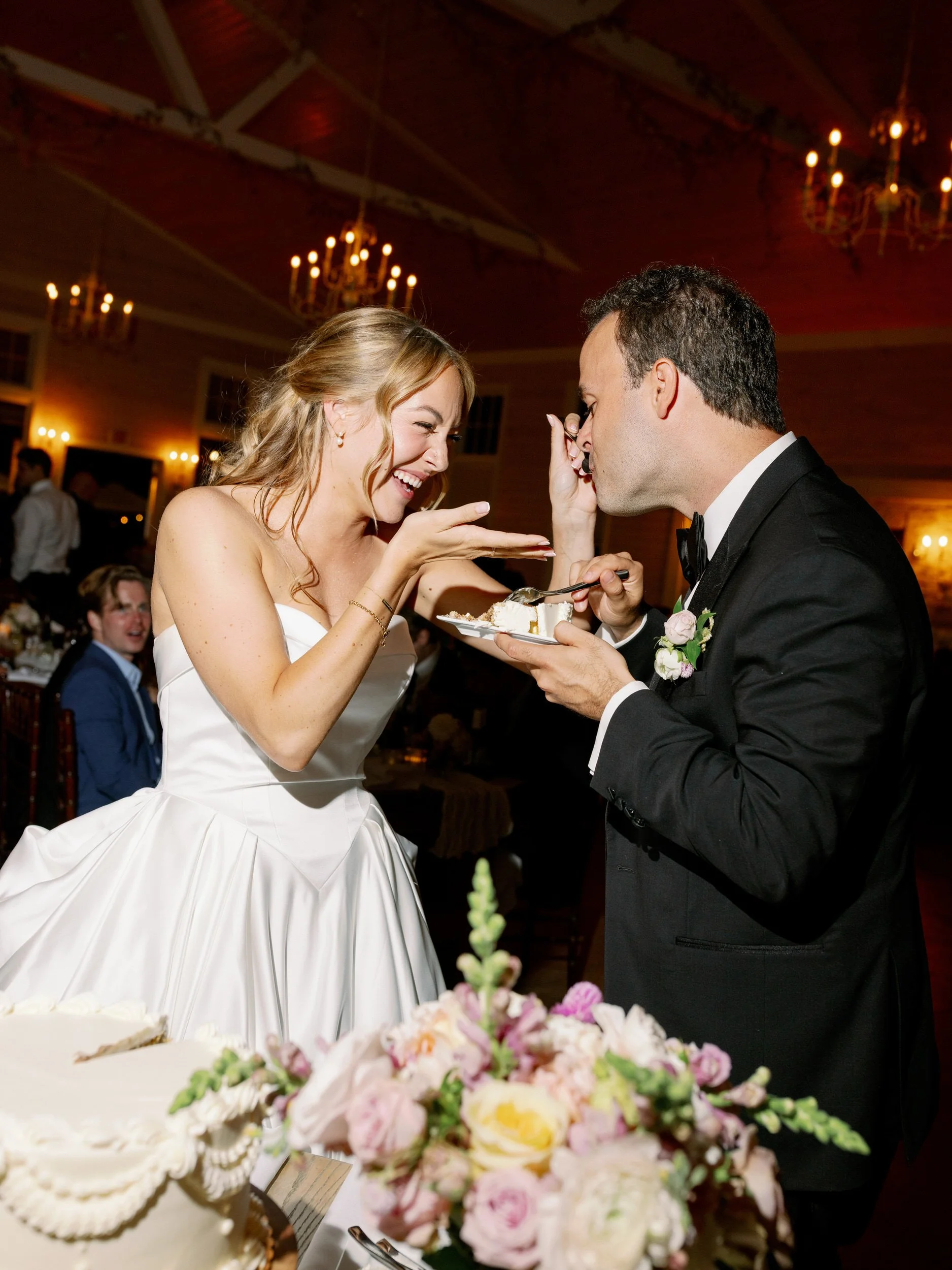 A newlywed feeding their partner cake at their wedding reception